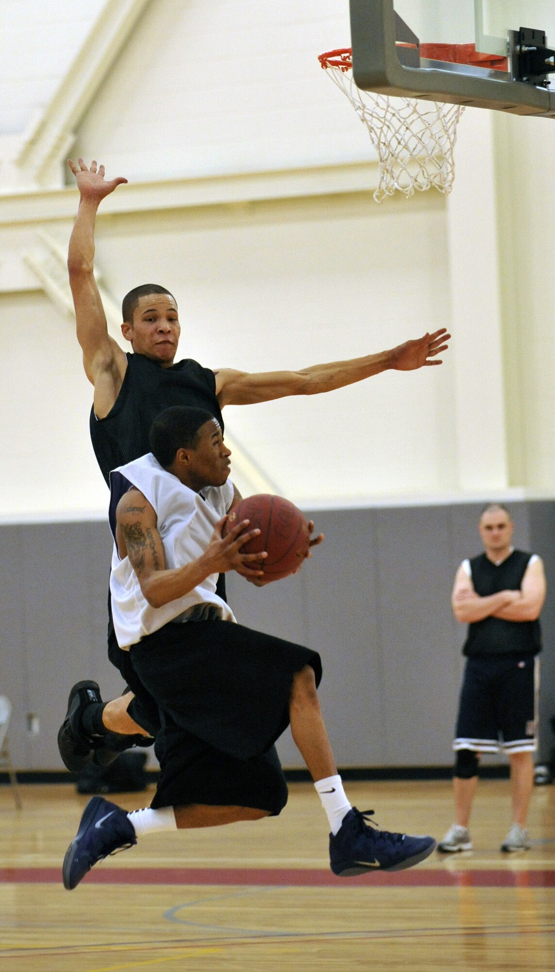 Redmond Ellison, guard with the 436th Logistics Readiness Squadron B team, goes up for a layup as Raul Rodriguez, forward for the 436th Maintenance Squadron, defends during the base intramural basketball championship game at the Base Fitness Center March 14, 2012, on Dover Air Force Base, Del. The 436th LRS B won the championship defeating the 436th MXS 53-31 and 40-33. (U.S. Air Force photo by Tech. Sgt. Chuck Walker)