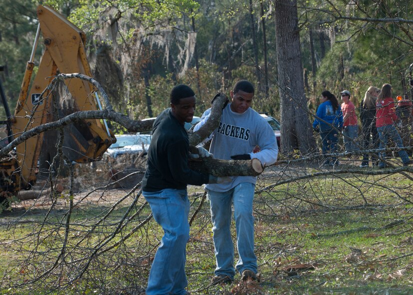 U.S. Air Force Staff Sgt. Albert Whidby and Airman 1st Class Samuel Jackson, both from the 23d Operation Support Squadron, haul large branches cut from fallen trees at a house in Lakeland, Ga., March 17, 2012. The home was hit by a tornado that registered up to 140 mph March 3. Moody volunteers joined members of the community to help clean up debris created by the storm. (U.S. Air Force photo by Senior Airman Eileen Meier/Released)
