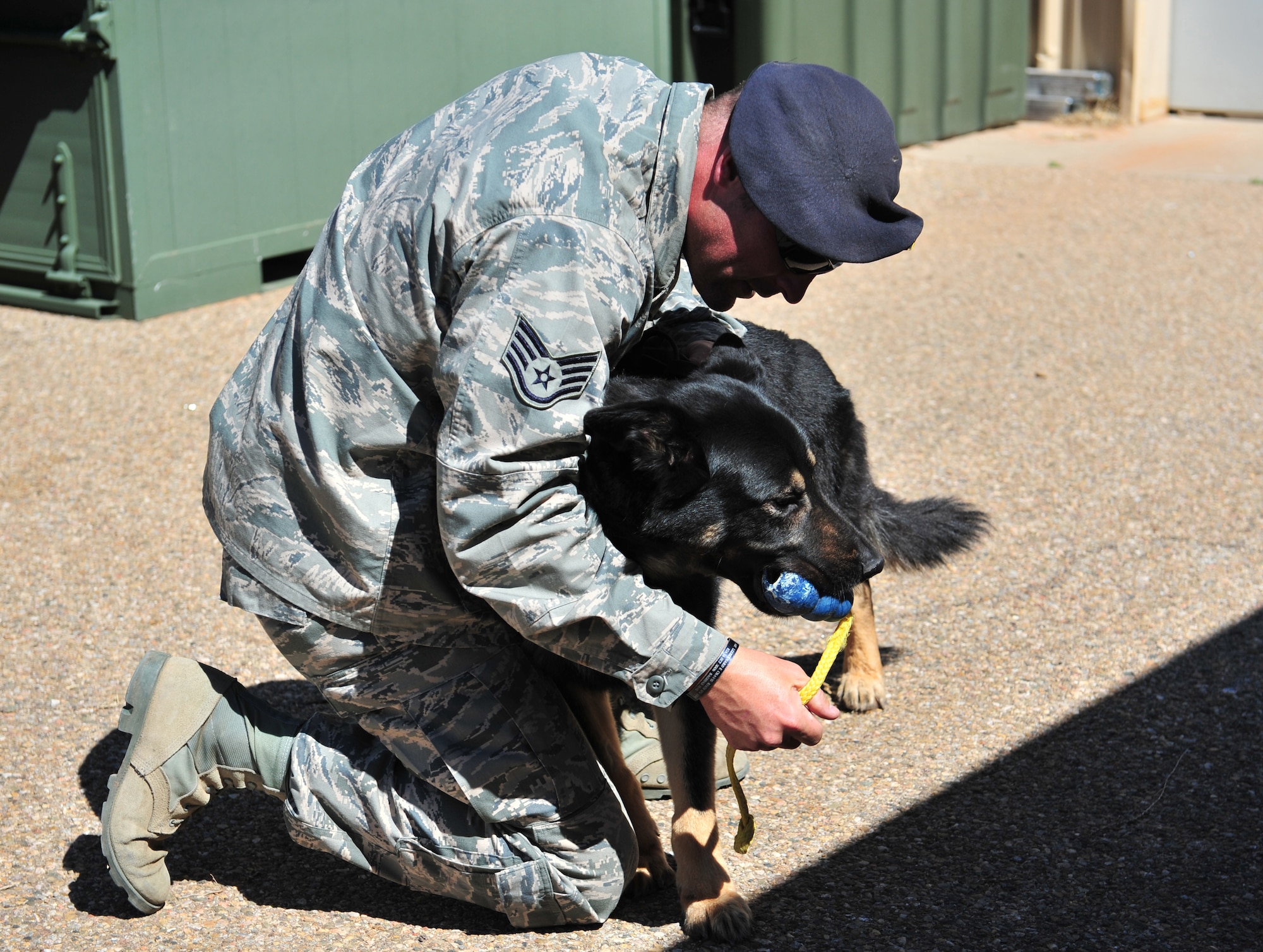 U.S. Air Force Staff Sgt. Adam Wylie, 27th Special Operations Security Forces Squadron military working dog handler, praises and rewards K-9 unit Dino K014 with a rubber Kong chew toy after locating a training aid at Cannon Air Force Base, N.M., March 15, 2012. Training aids can either be drugs or explosives based on what the dog?s certifications are. (U.S. Air Force photo by Airman 1st Class Alexxis Pons Abascal)