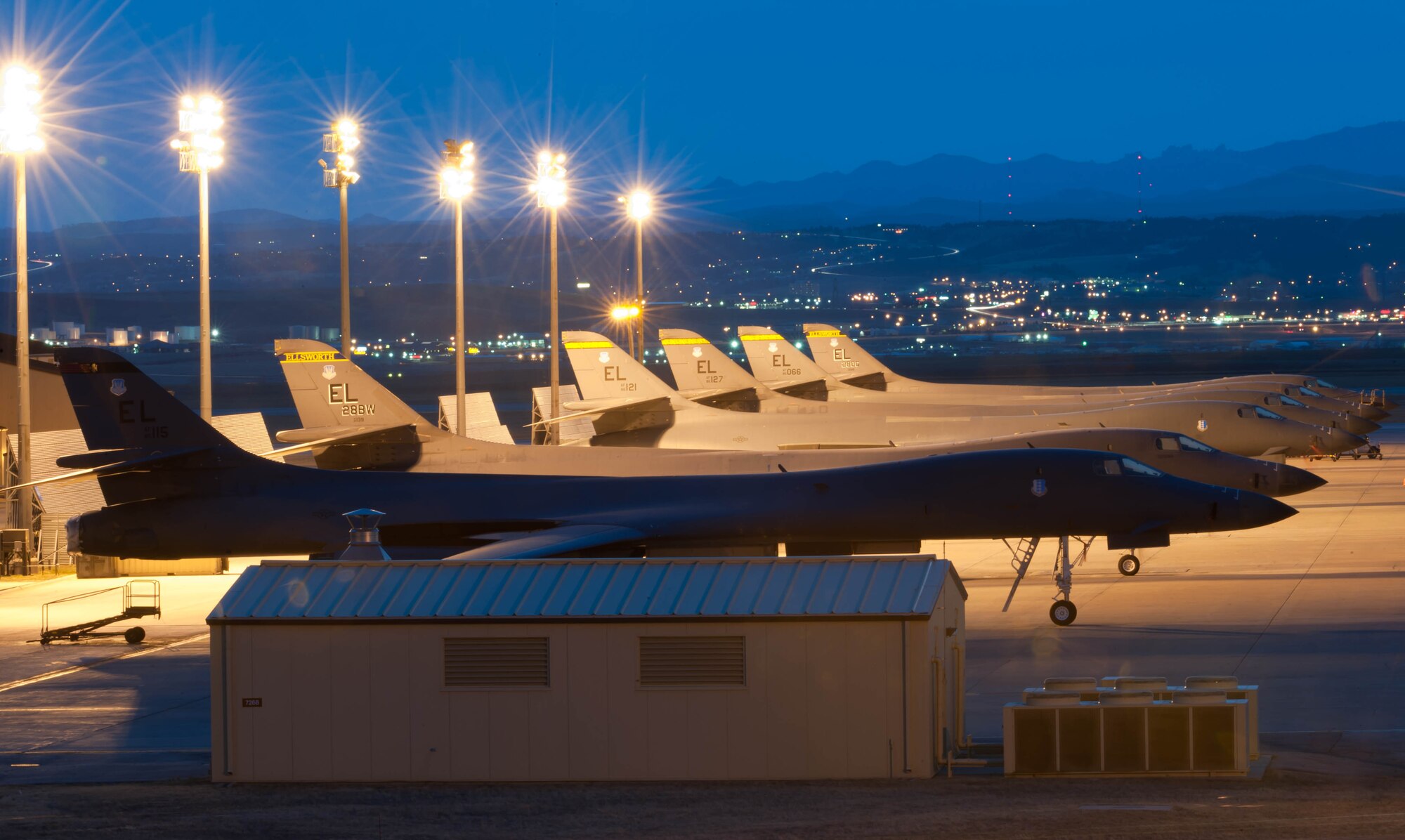 Six B-1 bombers sit silently on the aircraft parking area on the first evening of an Operational Readiness Exercise at Ellsworth Air Force Base, S.D., March 14, 2012. The B-1s had been prepared for a series of exercises designed to test the base’s ability to process and mobilize personnel, aircraft and associated equipment. (U.S. Air Force photo by Airman 1st Class Zachary Hada/Released)