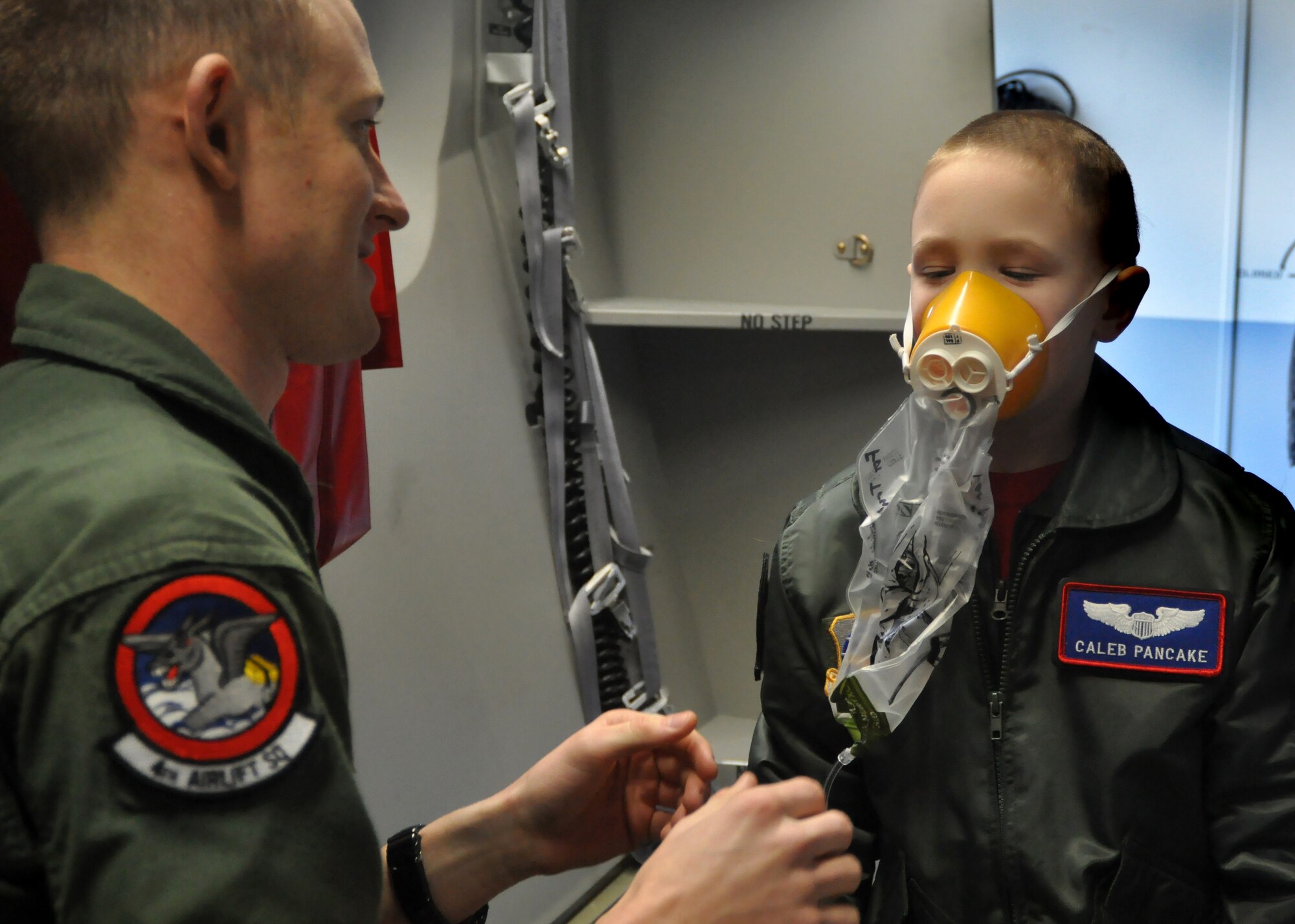 Senior Airman Jordan Rayman, 4th Airlift Squadron loadmaster, teaches Caleb Pancake different functions of a C-17 Globemaster III and its equipment as part of the Pilot for a Day program March 16, 2012, at Joint Base Lewis-McChord, Wash. (U.S. Air Force photo/Airman 1st Class Leah Young)