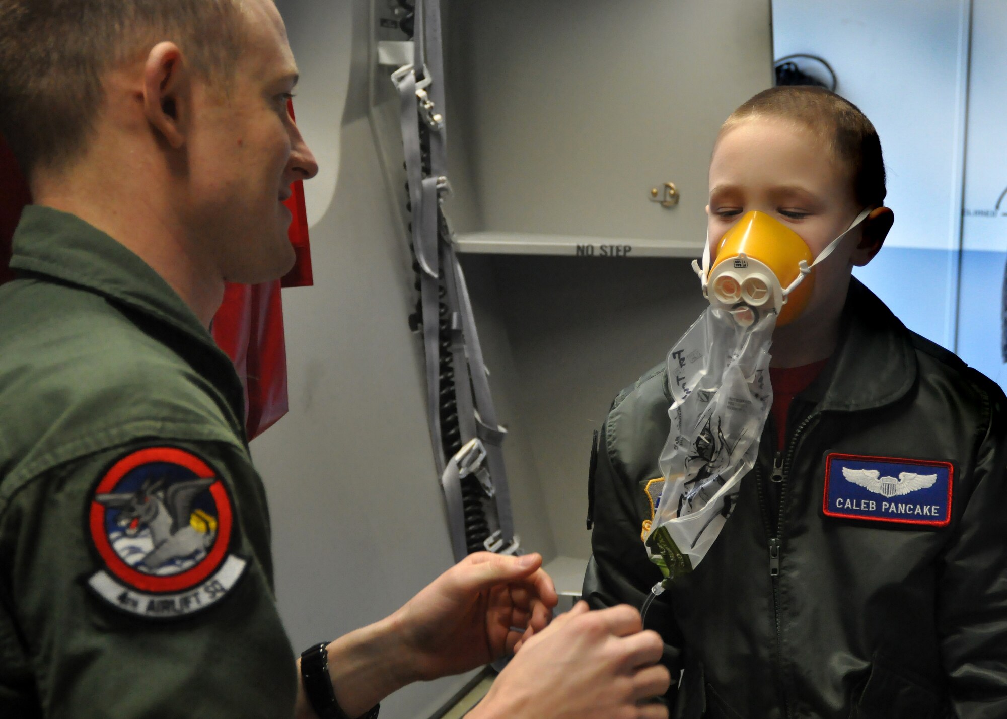 Senior Airman Jordan Rayman, 4th Airlift Squadron loadmaster, teaches Caleb Pancake different functions of a C-17 Globemaster III and its equipment as part of the Pilot for a Day program March 16, 2012, at Joint Base Lewis-McChord, Wash. (U.S. Air Force photo/Airman 1st Class Leah Young)