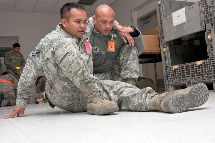 U.S. Air Force Staff Sgt. Marcus Laurico, 99th Medical Group aerospace medical technician (right) performs self aide and buddy care for Staff Sgt. Chris Hubenthal 99th Air Base Wing Public Affairs photojournalist (left). The scenario simulated an injury that occurred on the flight line during an operational readiness exercise March 19, 2012, at Nellis Air Force Base, Nev. (U.S. Air Force photo by Airman 1st Class Jason Couillard)