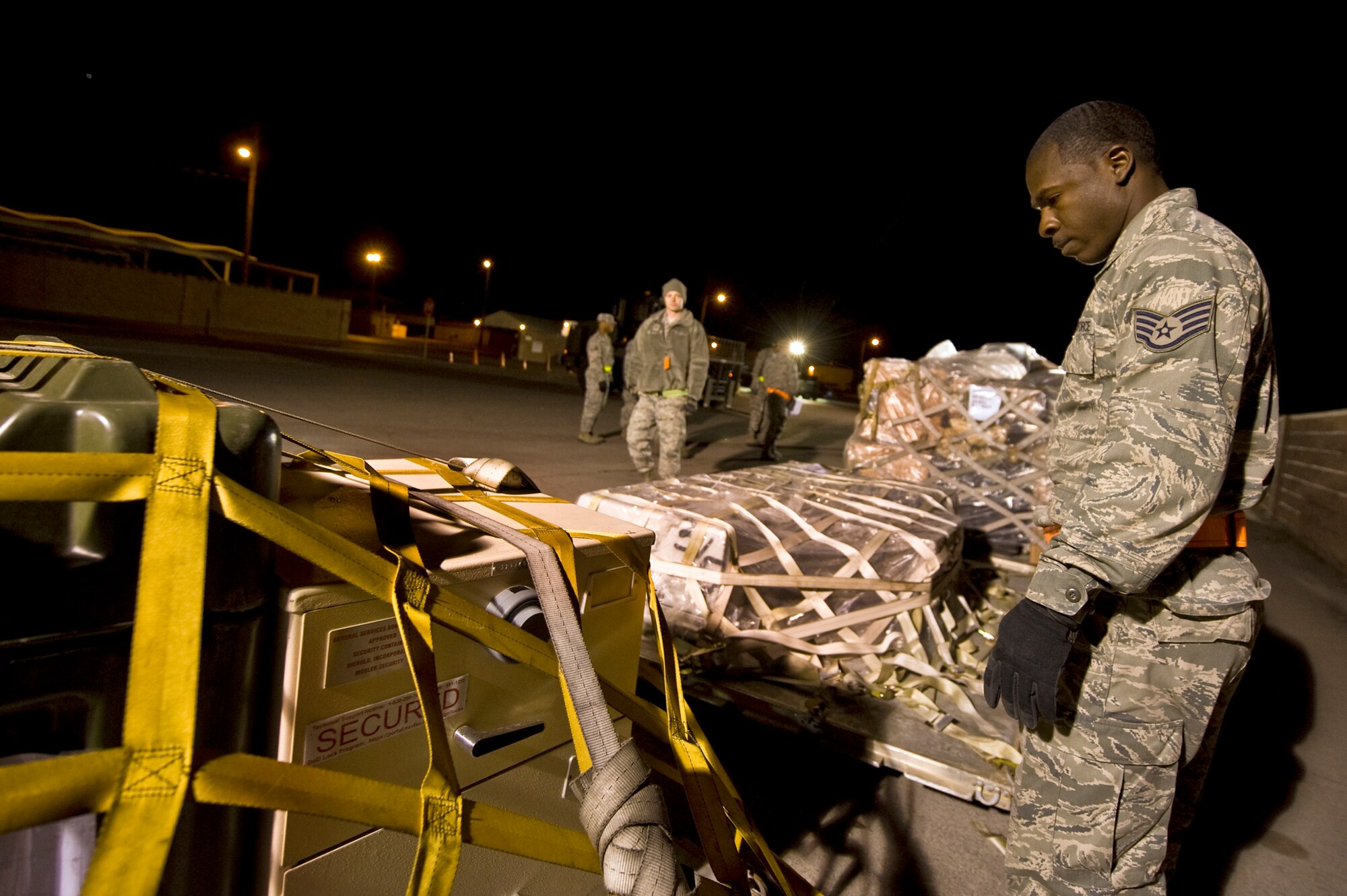 U.S. Air Force Staff. Sgt. Darnell Roberts, 99th Force Support Squadron services specialist, ensures all cargo straps are secured prior to loading an aircraft during an operational readiness exercise March 19, 2012, at Nellis Air Force Base, Nev. The exercise tests the wing's capability to deploy personnel and equipment to perform their mission at forward deployed locations worldwide. (U.S. Air Force photo by Airman 1st Class Daniel Hughes)
