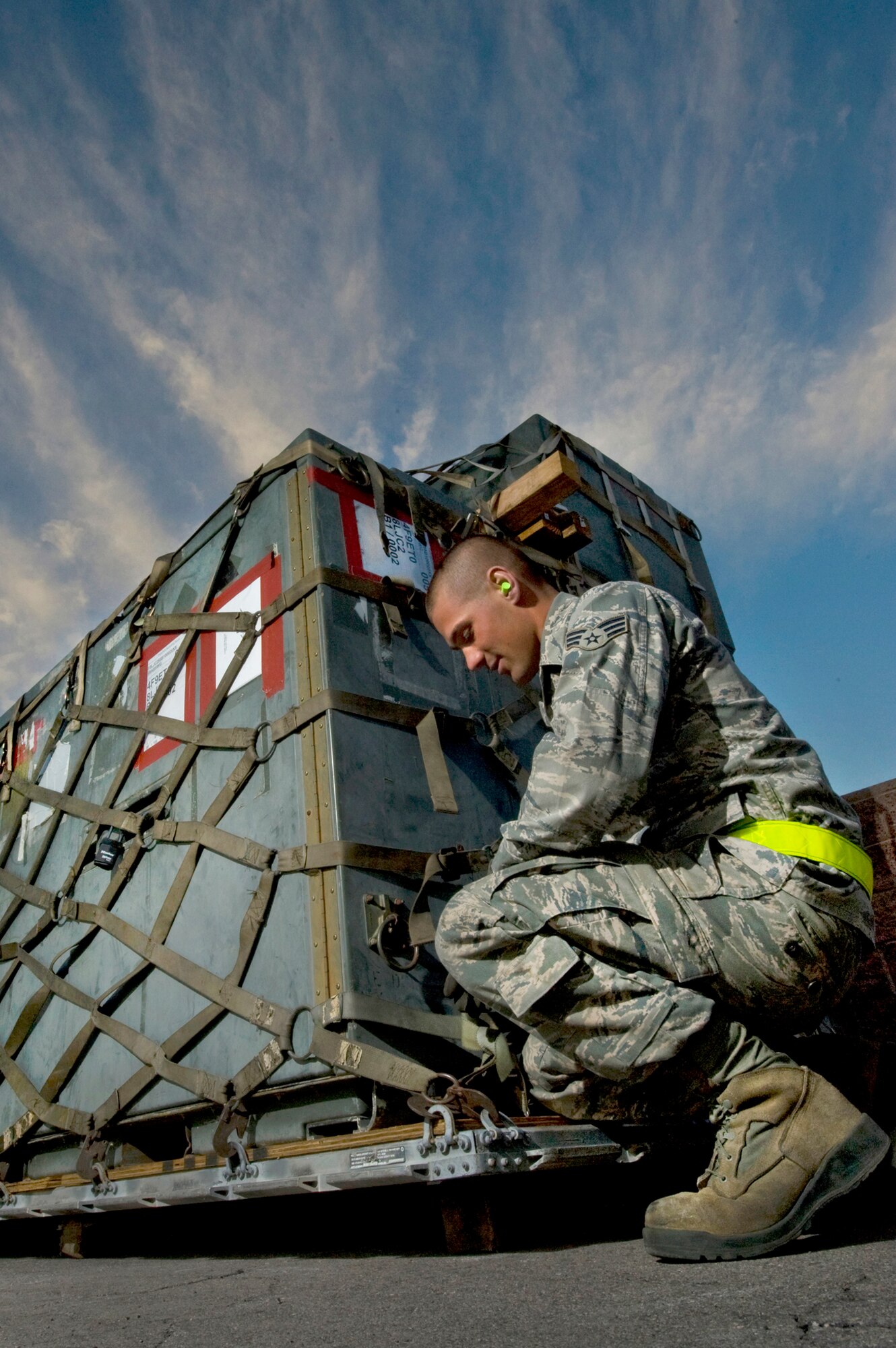 U.S. Air Force Senior Airman Nicholas Kirchner, 99th Air Base Wing Logistics Readiness Squadron air transportation journeyman, secures a cargo safety net to a pallet during an operational readiness exercise March 19, 2012, at Nellis Air Force Base, Nev. The exercise tested the 99th Air Base Wing's capability to deploy personnel, weapon systems and equipment to perform its mission worldwide. (U.S. Air Force photo by Airman 1st Class Daniel Hughes)