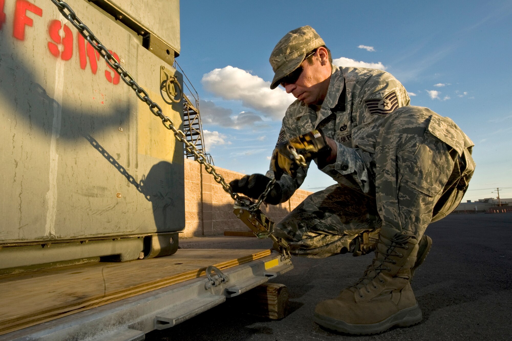 U.S. Air Force Tech. Sgt. Humberto Correa, 99th Civil Engineer Squadron, heating ventilation and air conditioning craftsman, ratchets down cargo to a 463L pallet during an operational readiness exercise March 19, 2012, at Nellis Air Force Base, Nev.
The exercise began with a recall of forces to initiate a simulated short-notice deployment.  (U.S. Air Force photo by Airman 1st Class Daniel Hughes)
