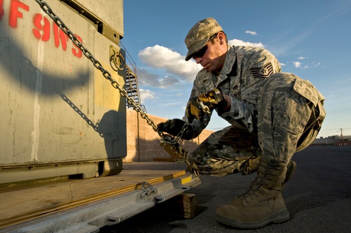 U.S. Air Force Tech. Sgt. Humberto Correa, 99th Civil Engineer Squadron, heating ventilation and air conditioning craftsman, ratchets down cargo to a 463L pallet during an operational readiness exercise March 19, 2012, at Nellis Air Force Base, Nev.The exercise began with a recall of forces to initiate a simulated short-notice deployment.  (U.S. Air Force photo by Airman 1st Class Daniel Hughes)