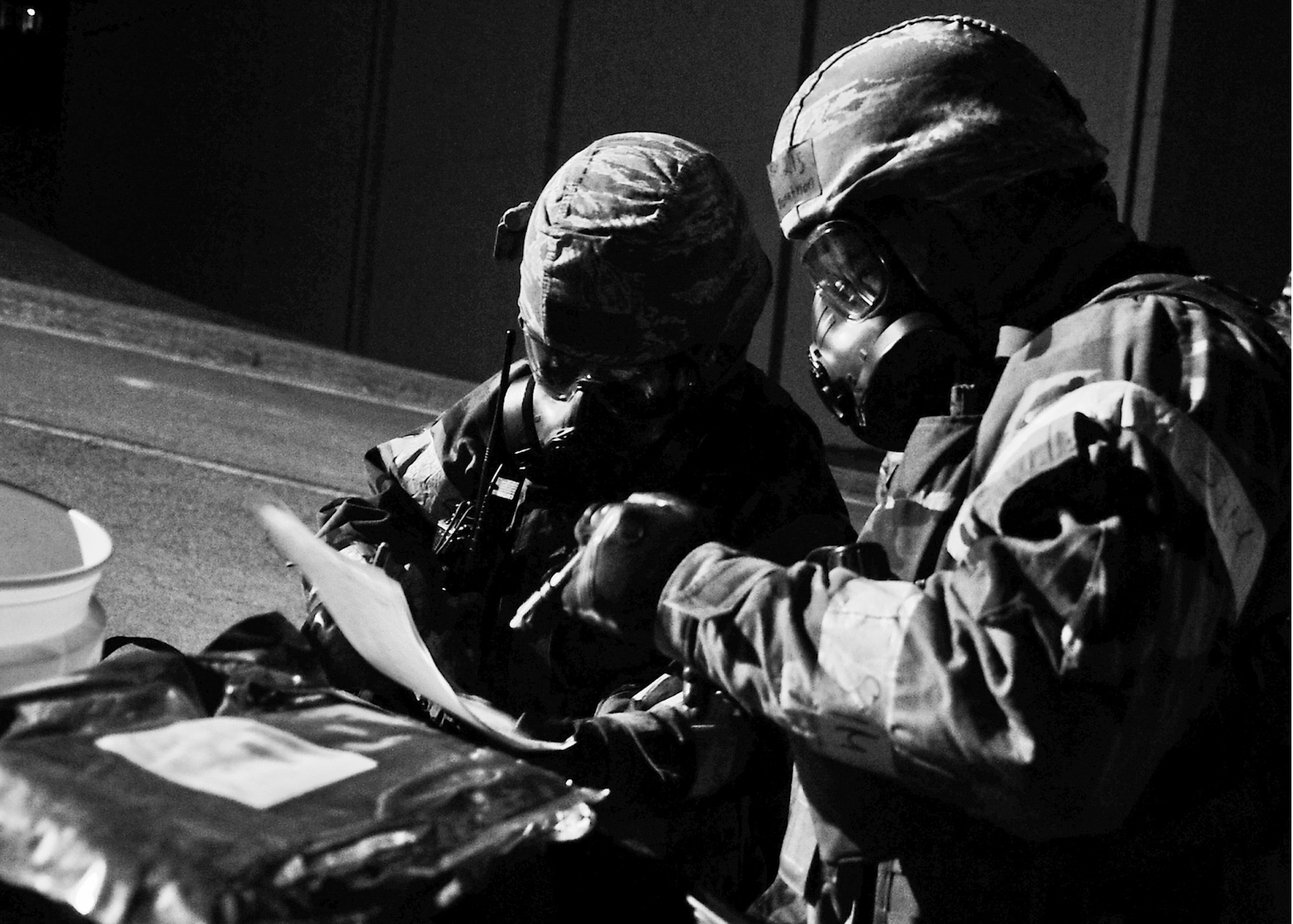 Airmen from the 51st Civil Engineer Squadron emergency management section, look over a checklist while sampling airborne material March 19, 2012, during exercise Beverly-Midnight 12-01. Exercises such as this test Osan's ability to survive and operate during war while also testing the ability to plan and execute an exercise. (U.S. Air Force photo/Senior Airman Adam Grant)