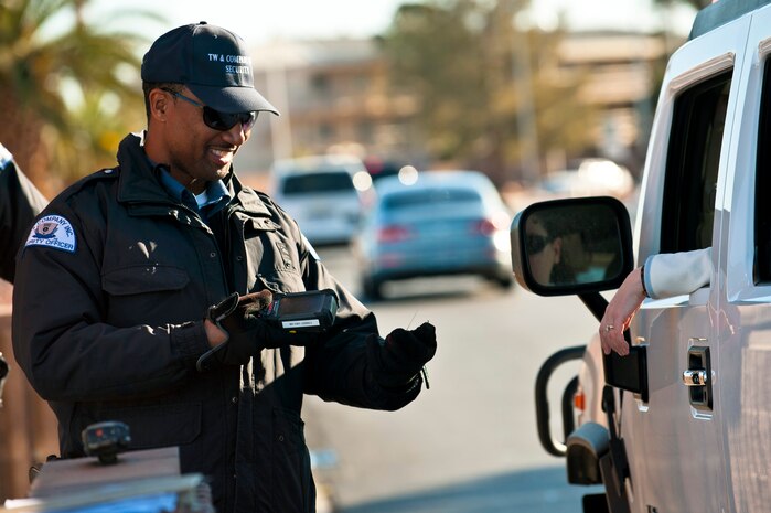 Paris Garrett, TW and Company security officer, scans identification cards using a biometric identification sensor at the Nellis Main Gate, March 20, 2012 at Nellis Air Force Base, Nev. Nellis is introducing a new security program, the Defense Biometric Identification System, to manage personnel, property and installation access. (U.S. Air Force photo by Senior Airman Brett Clashman)