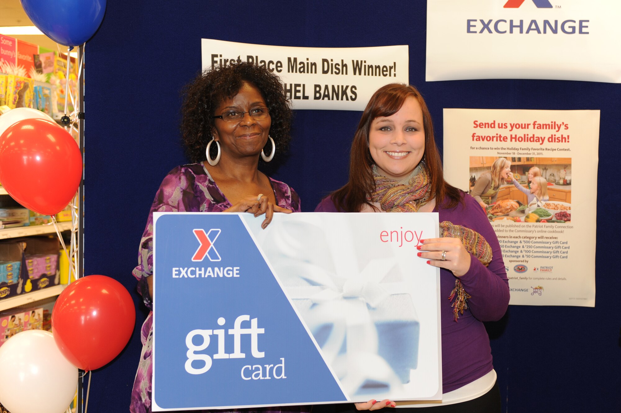 Harriet Britt, left, presents Rachel Banks a $500 Exchange gift card in the Exchange at Seymour Johnson Air Force Base, N.C., March 14, 2012. Banks placed first in the Holiday Family Favorite Contest, winning $500 gift cards from the Exchange and commissary. Banks, wife of Senior Airman Joshua Banks, 916th Air Refueling Wing command post controller, is from Charlotte, N.C. Britt, Exchange softline manager, hails from Sumter, S.C. (U.S. Air Force photo/Airman 1st Class John Nieves Camacho/Released)