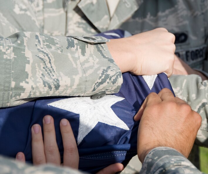 Airmen from the Barksdale Honor Guard ensure the American flag is properly folded during a retreat ceremony held by the 2nd Mission Support Group here, March 14. The flag detail ensures no red shows from the stripes when the flag is completely folded properly. If any red is showing, the detail would have to unfold it and retry the procedure. (U.S. Air Force photo/Airman 1st Class Benjamin Gonsier)(RELEASED)