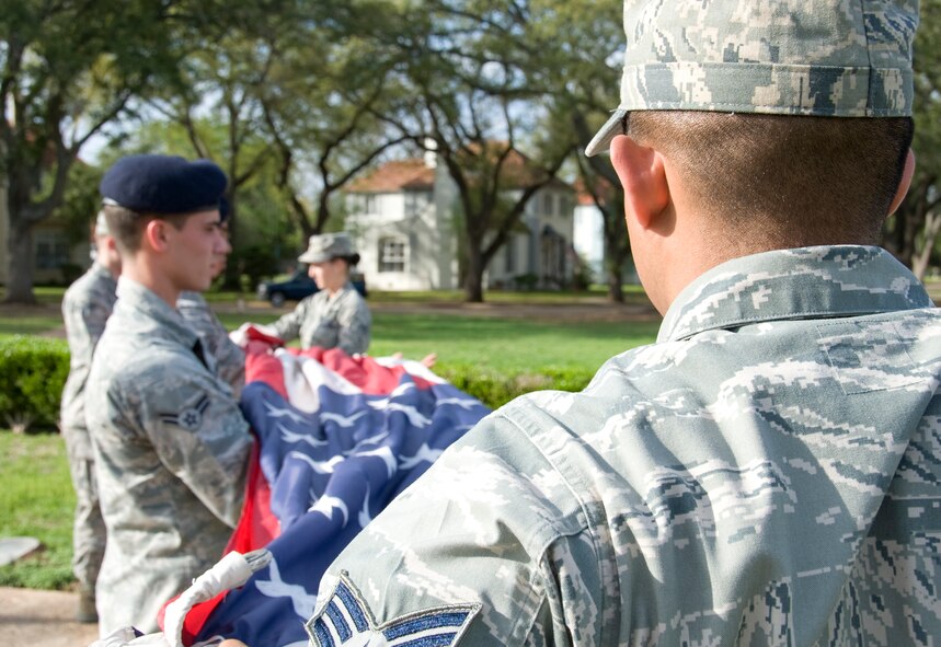 Airmen from the Barksdale Honor Guard fold the American flag during a retreat ceremony held by the 2nd Mission Support Group here, March 14. The flag is folded into a triangular shape beginning from the striped side. (U.S. Air Force photo/Airman 1st Class Benjamin Gonsier)(RELEASED)