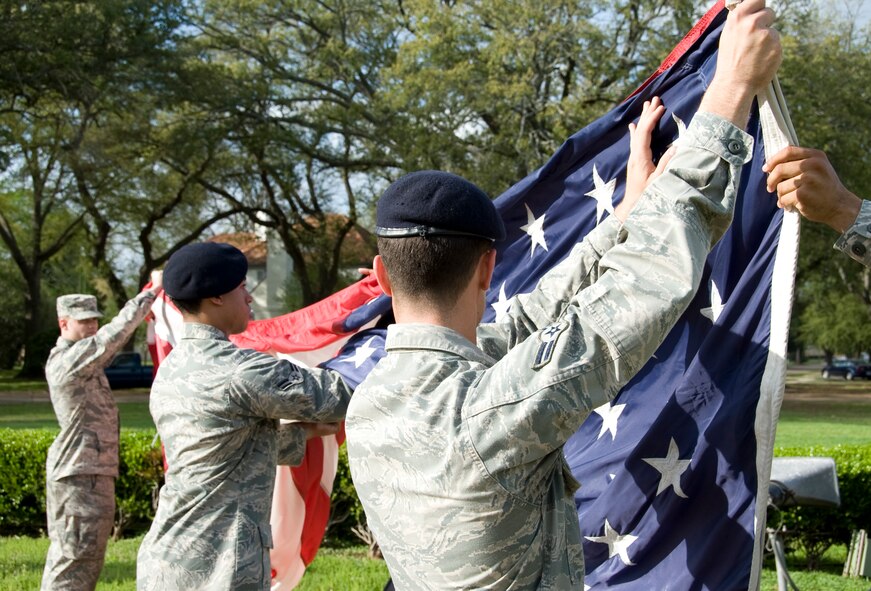 Airmen from the Barksdale Honor Guard fold the American flag during a retreat ceremony held by the 2nd Mission Support Group here, March 14. The flag is folded two times to decrease the size of the width and then folded in a triangular shape starting from the stripes. (U.S. Air Force photo/Airman 1st Class Benjamin Gonsier)(RELEASED)