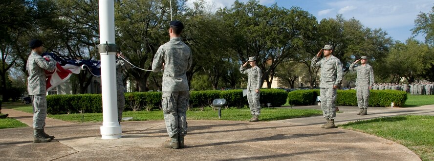 Airmen from the Barksdale Honor Guard salute the American flag during a retreat ceremony here, March 14. It is disrespectful for the flag to touch the ground, so one Airman is designated to catch the flag before it does. (U.S. Air Force photo/Airman 1st Class Benjamin Gonsier)(RELEASED)
