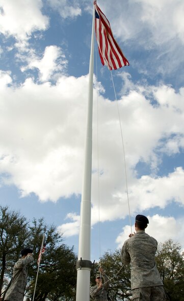 Airmen from the Barksdale Honor Guard lower the American flag during a retreat ceremony held by the 2nd Mission Support Group here, March 14. During the ceremony, the flag is lowered by two halyards as the rest of the honor guard team salutes the flag. (U.S. Air Force photo/Airman 1st Class Benjamin Gonsier)(RELEASED)
