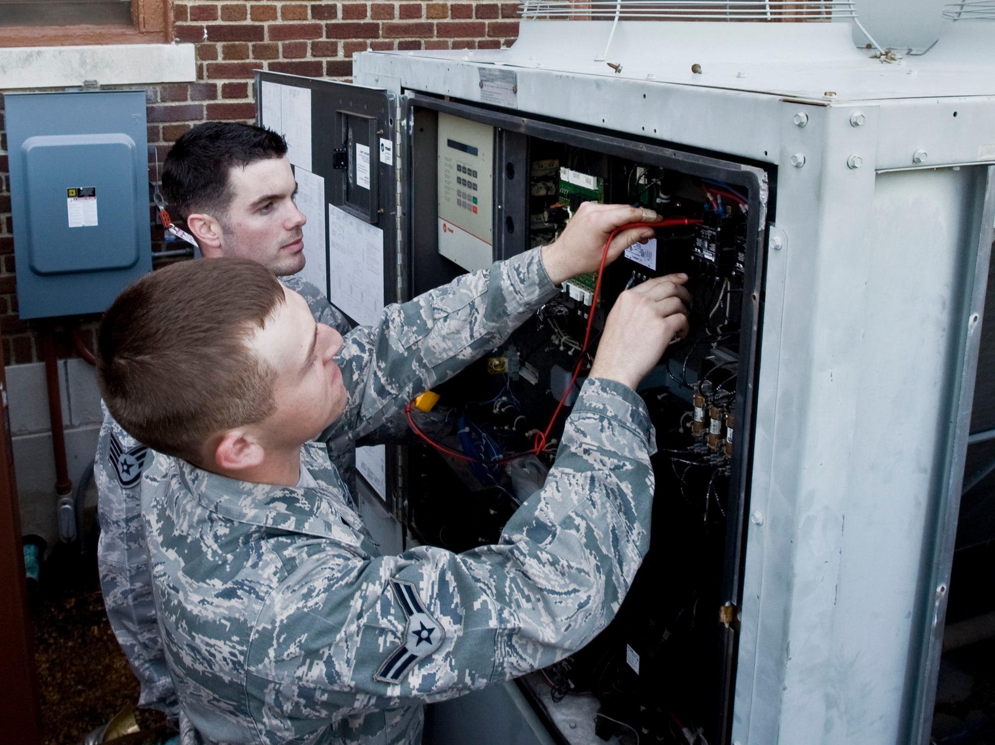 U.S. Air Force Staff Sgt. Michael Murphy II,  633rd Civil Engineer Squadron heating, ventilation and air conditioning craftsman, Airman 1st Class William Davey, 633rd CES HVAC apprentice, troubleshoot a chiller March 19, 2012, at Langley Air Force Base, Va. Troubleshooting allows HVAC Airmen to properly identify a problem within a system without disassembling it. (U.S. Air Force photo by Senior Airman Stephanie Rubi/Released)