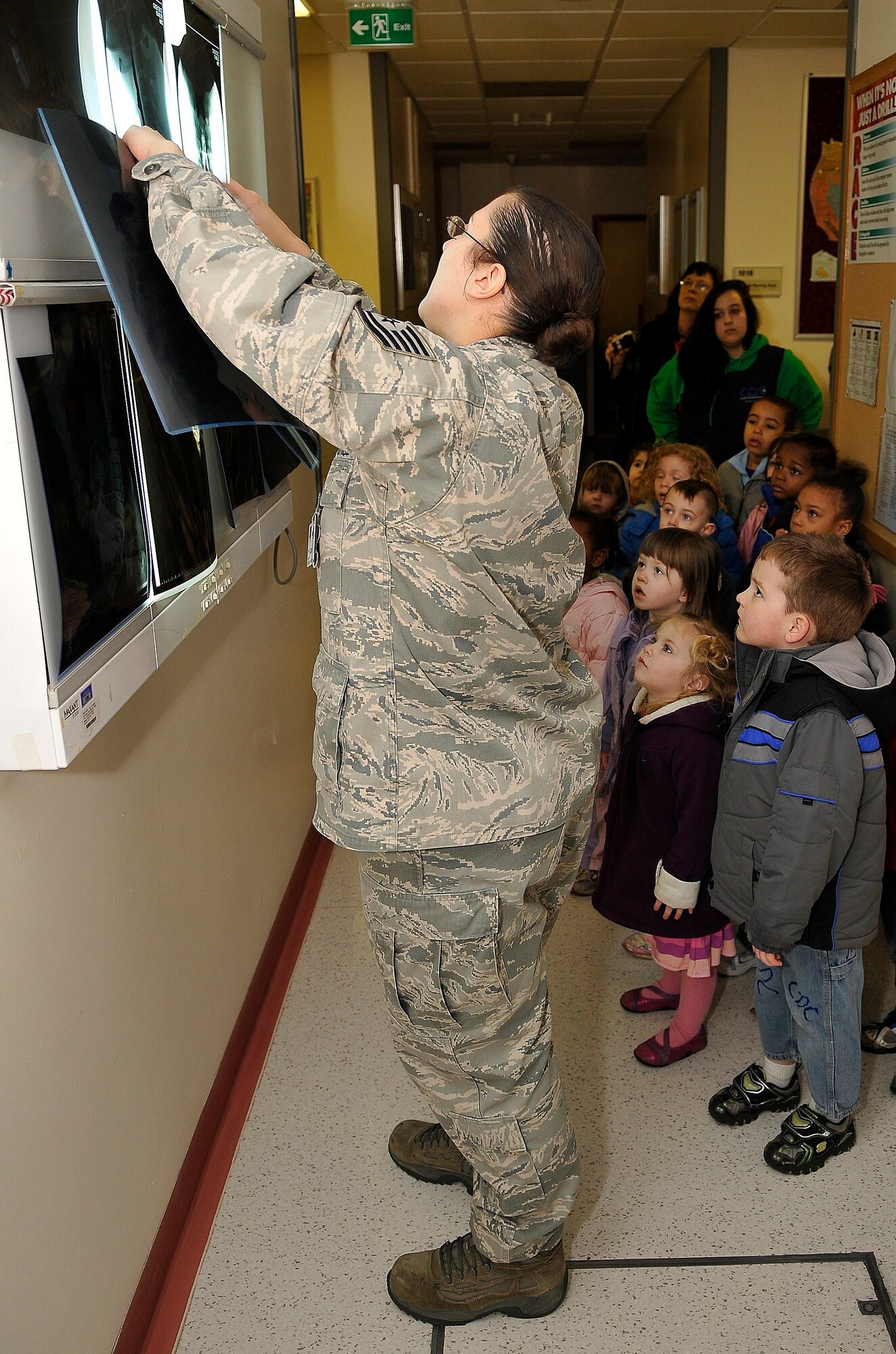 ROYAL AIR FORCE LAKENHEATH, England -- Tech. Sgt. Heather Thomas, 48th Medical Group computed tomography NCO in charge, shows children from the Child Development Center West X-rays during a visit to the RAF Lakenheath Hospital?s radiology section March 16, 2012.  The children toured the radiology and optometry departments to learn more about the human body and were given the opportunity to see and use various medical equipment. (U.S. Air Force photo by Staff Sgt. Connor Estes)