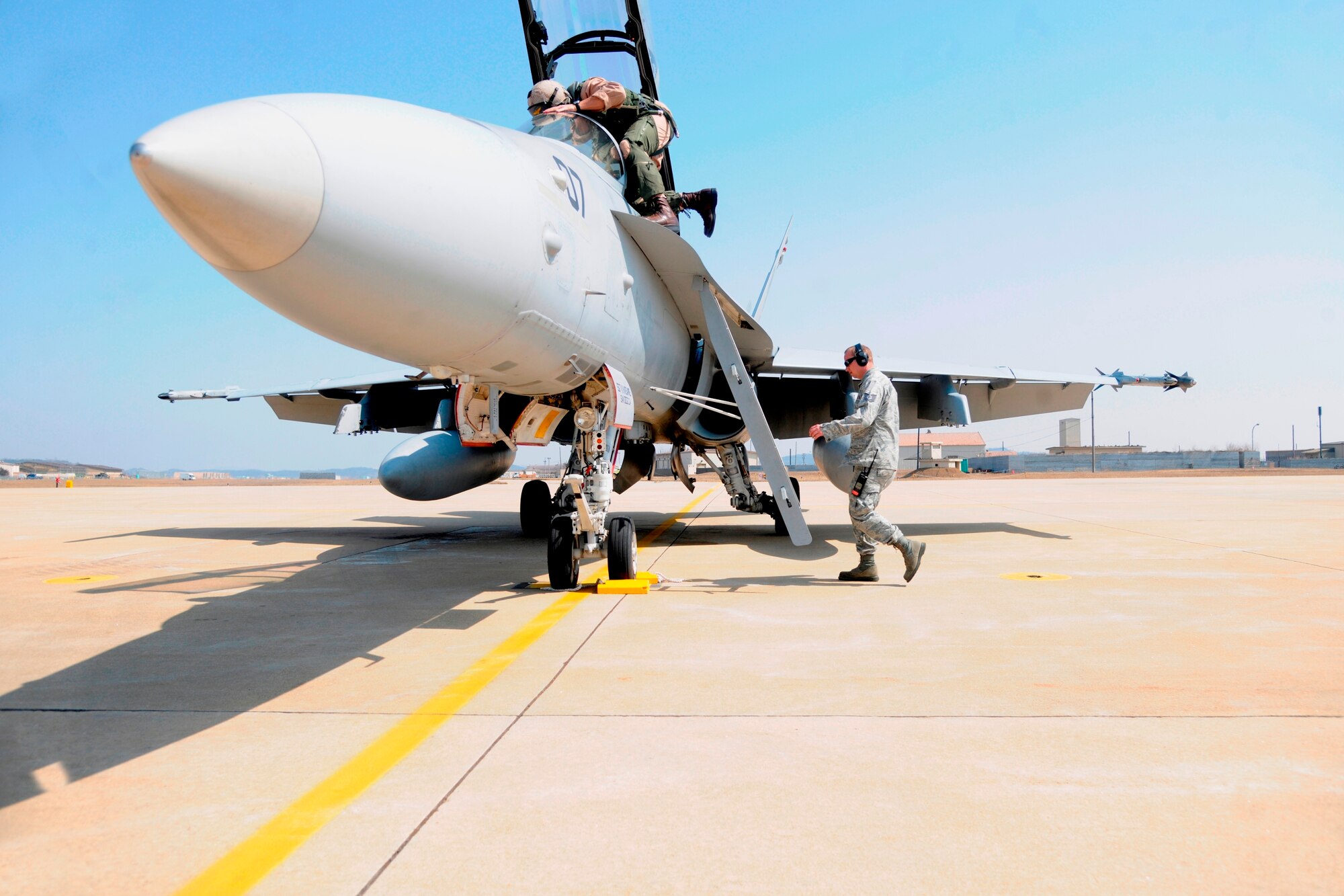 A U.S. Marine Corps fighter pilot from the Marine All Weather Fighter Attack Squadron 121 preps his F/A-18D Hornet at Kunsan Air Base, Republic of Korea, March 15, 2012. He and other Marine Corps pilots currently deployed to MCAS Iwakuni, Japan, from Marine Corps Air Station Miramar, Calif., participated in air-to-air training with F-16 Fighting Falcon pilots from the 35th Fighter Squadron at Kunsan AB. The training was essential to help them be mission-ready to take the fight to the skies. (U.S. Air Force photo by Staff Sgt. Rasheen Douglas/Released)