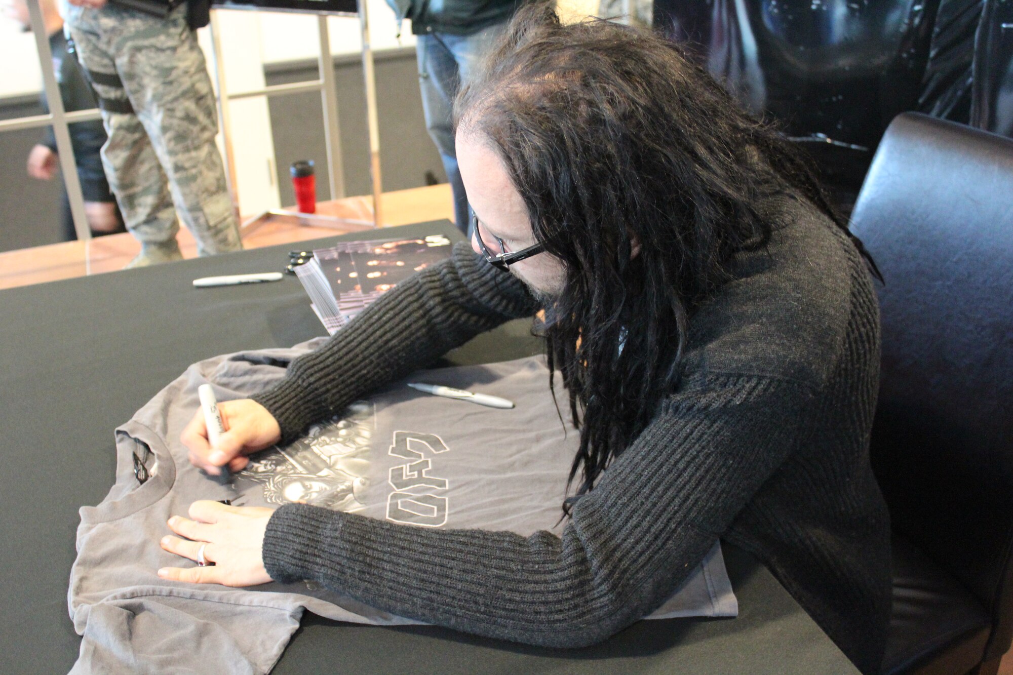 Jonathan Davis, lead singer of the band KoRn, signs a t-shirt for a fan at the Kaiserslautern Military Community Center, 16 March 2012, Ramstein Air Base, Germany. Davis toured the base to visit various units and sign autographs for his fans. (U.S. Air Force Photo/ Airman 1st Class Ellen McCarthy)