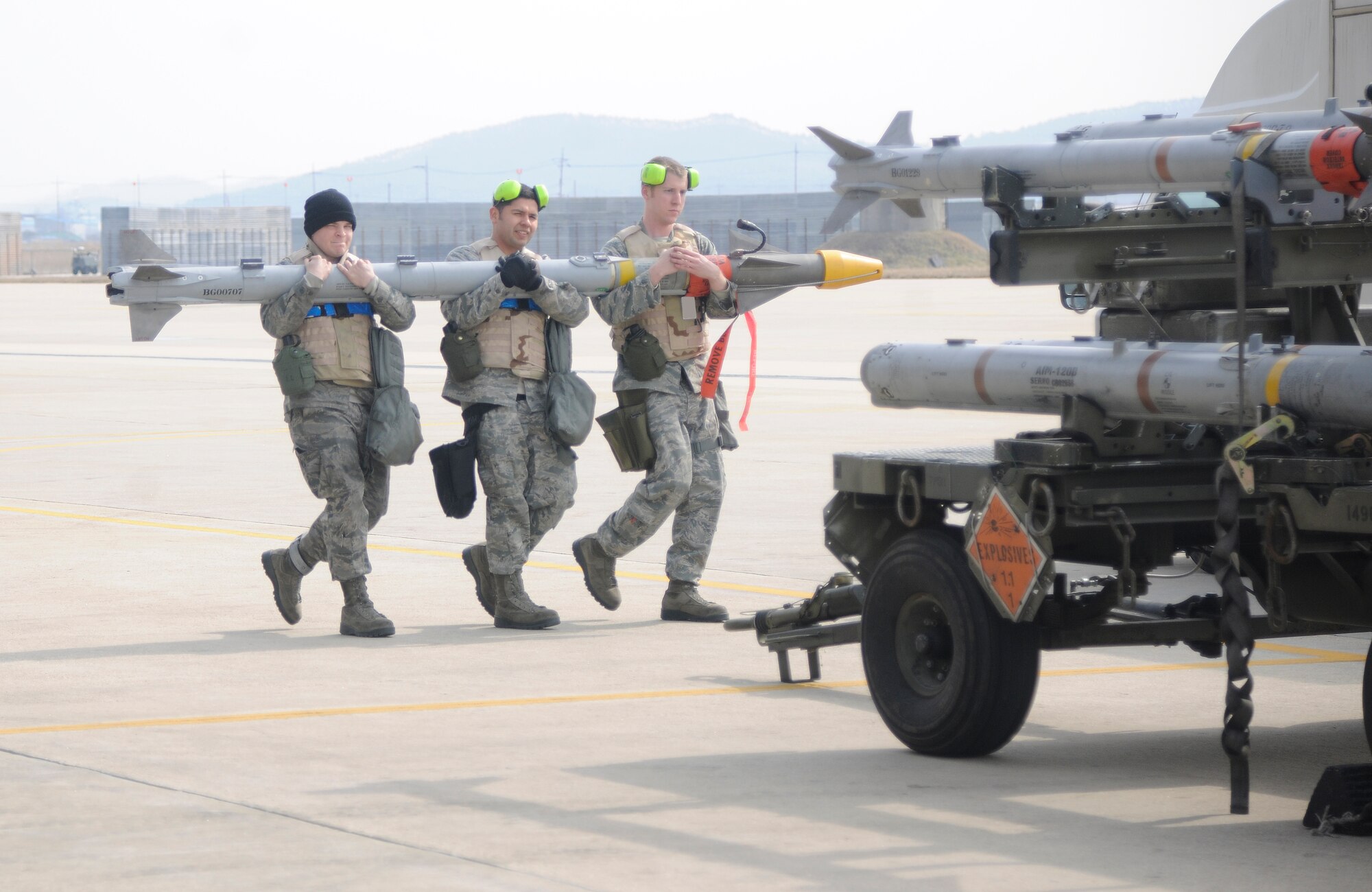 Airmen from the 20th Expeditionary Aircraft Maintenance Squadron, deployed from Shaw Air Force Base, S.C., to South Korea, carry a missile back to a stand after practicing loading them onto an F-16 Fighting Falcon during an operational readiness exercise at Kunsan Air Base, Republic of Korea, March 19, 2012. Base exercises help ensure Wolf Pack Airmen are capable of performing their duties in wartime conditions. (U.S. Air Force photo by Staff Sgt. Rasheen A. Douglas/Released)