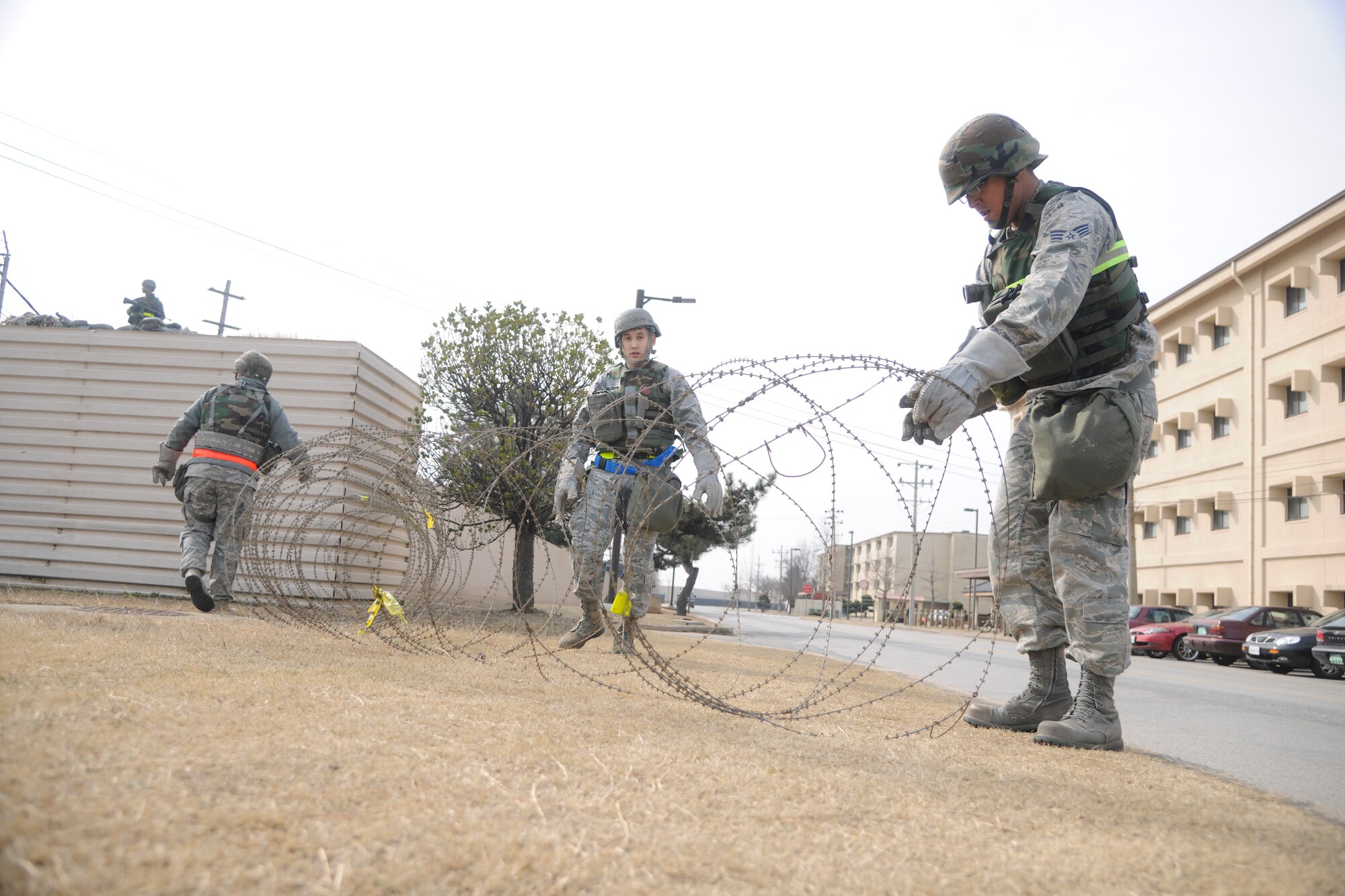 Members of the 8th Communications Squadron carry concertina wire to be set up at a perimeter during an operational readiness exercise at Kunsan Air Base, Republic of Korea, March 19, 2012. Wolf Pack Airmen, Soldiers and civilians have completed multiple rigorous exercises like this one to prepare for the base's upcoming Combined Unit Inspection. (U.S. Air Force Photo by Staff Sgt. Rasheen Douglas/Released)