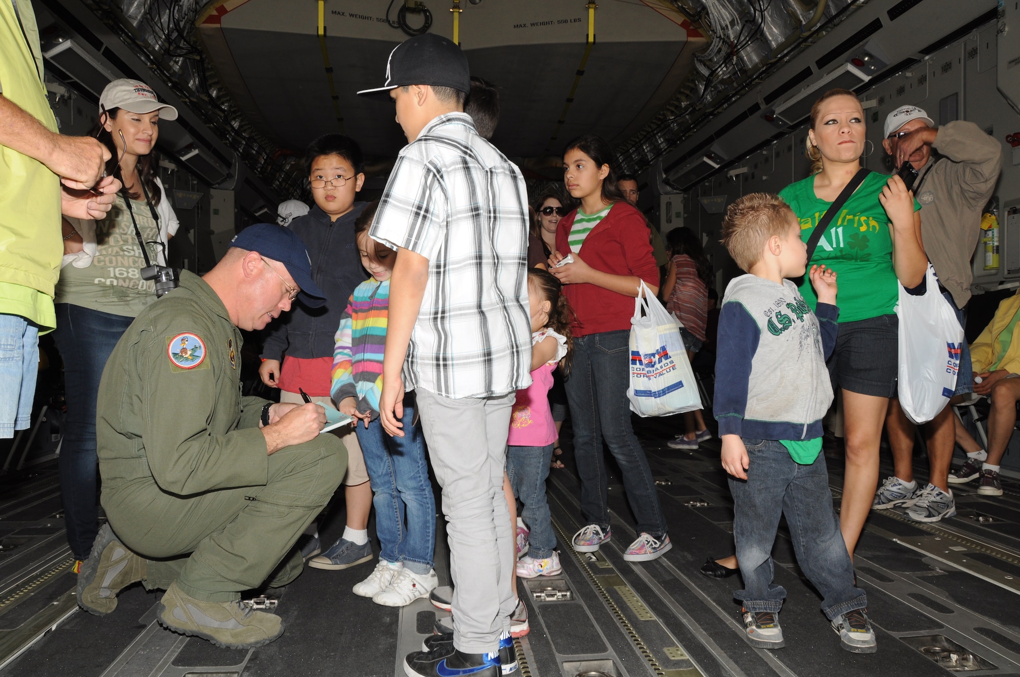 Master Sgt. Michael O’Brien signs a photograph of a C-17 Globemaster III aircraft for a family during the Marine Corps Air Station Yuma Airshow March 17, 2012. During the airshow, Sergeant O’Brien spent time educating airshow visitors about the aircraft, posing for photographs, signing autographs, and answering questions. More than 60,000 visitors attended the MCAS Yuma Airshow. Sergeant O’Brien is a loadmaster with the 701st Airlift Squadron at Joint Base Charleston, S.C. (U.S. Air Force photo/Staff Sgt. Shane Ellis)