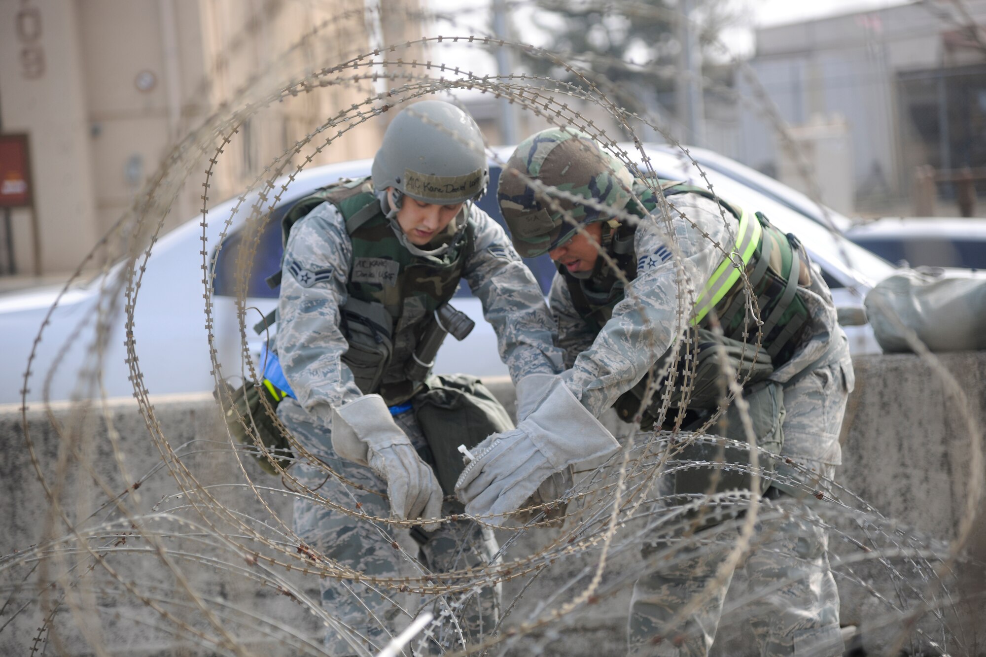 Senior Airman David Salazar and Airman 1st Class Daniel Kane, 8th Communications Squadron members, set up concertina wire for a perimeter during an operational readiness exercise at Kunsan Air Base, Republic of Korea, March 19, 2012. Wolf Pack Airmen, Soldiers and civilians have completed multiple, rigorous exercises to prepare for the Combined Unit Inspection. (U.S. Air Force Photo by Staff Sgt. Rasheen Douglas/Released)