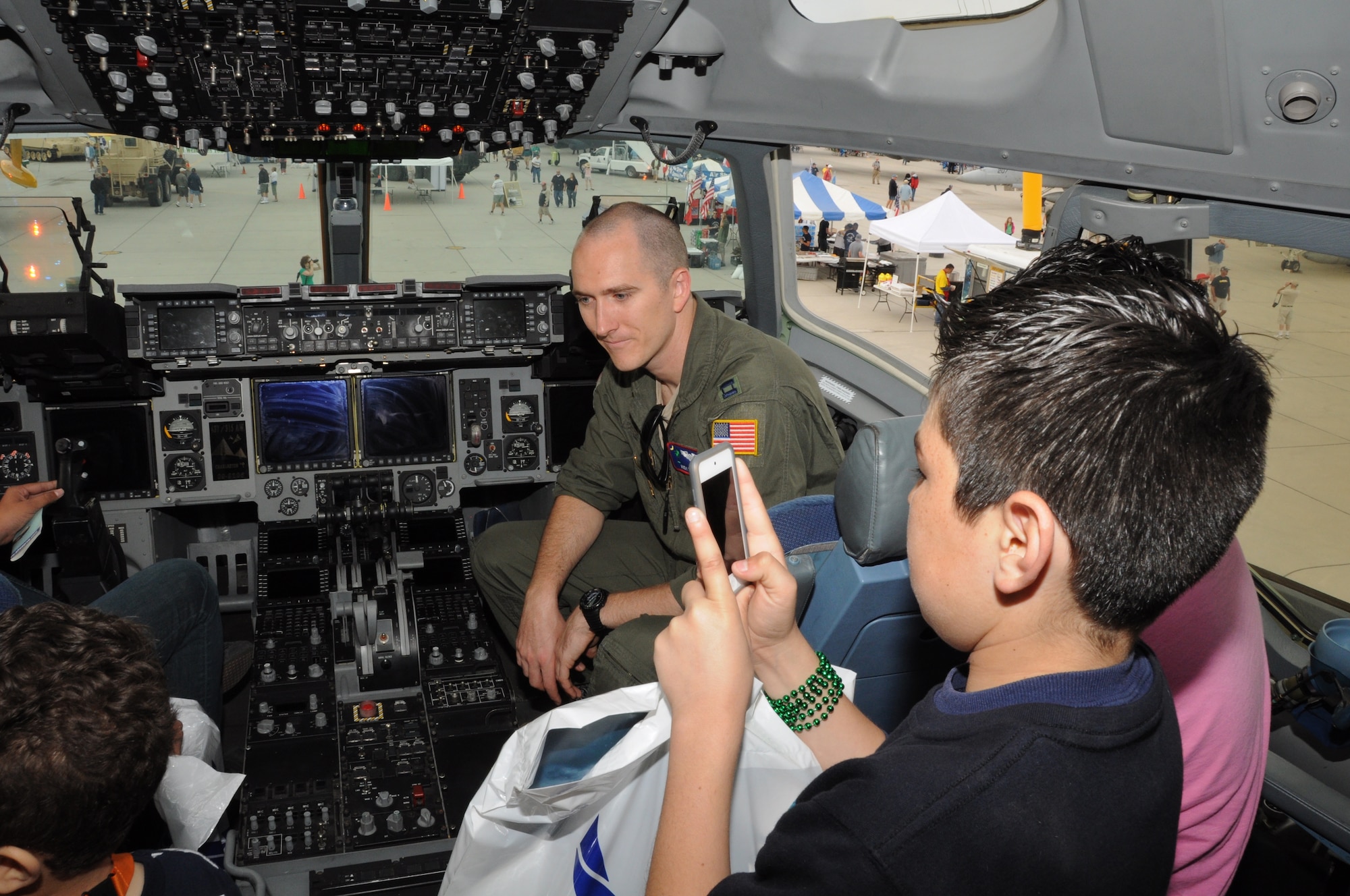 Capt. Andy Bean gives a tour of a C-17 Globemaster III flight deck at the Marine Corps Air Station Yuma Airshow March 17, 2012.  During the airshow, Captain Bean spent time educating airshow visitors about the aircraft, posing for photographs, signing autographs, and answering questions. More than 60,000 visitors attended the MCAS Yuma Airshow. Captain Bean is a C-17 pilot with the 701st Airlift Squadron at Joint Base Charleston, S.C. (U.S. Air Force photo/Staff Sgt. Shane Ellis)