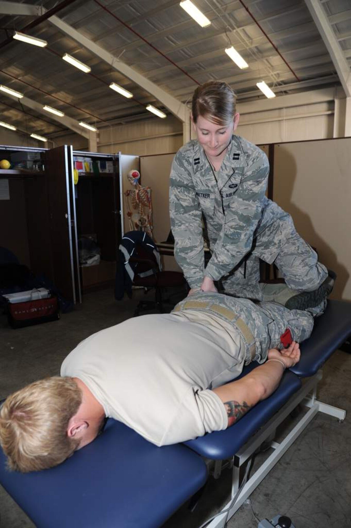 Capt. Danielle Schnitker, 23rd Special Tactics Squadron physical therapist, stretches the leg muscles of a combat controller assigned to the 23rd STS. Schnitker mainly works on combat related injuries providing daily physical therapy to help with recovery, lower injury rates and ensure Airmen are deployment ready. (U.S. Air Force photo by Master Sgt. Steven Pearsall)