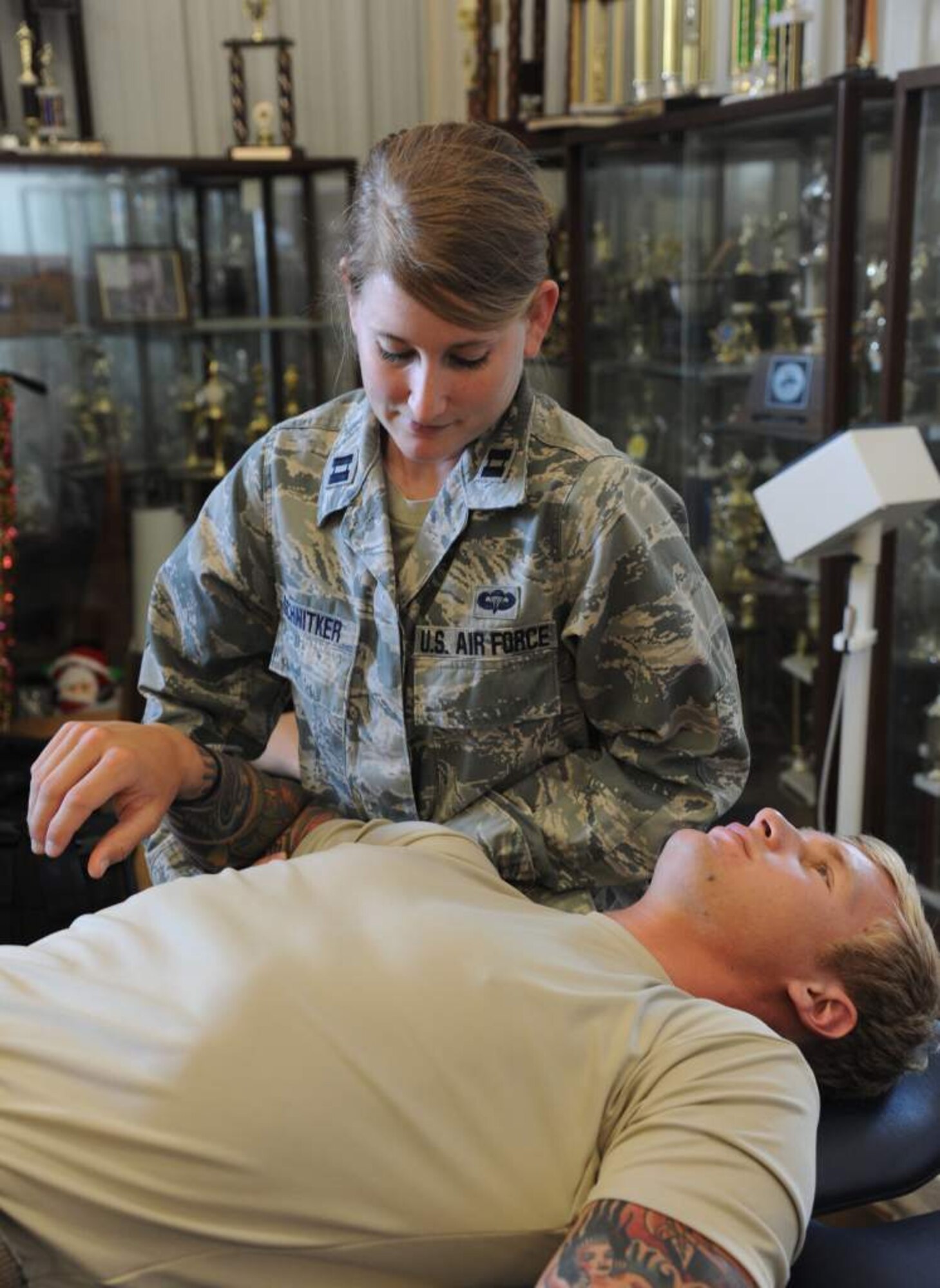 Capt. Danielle Schnitker, 23rd Special Tactics Squadron physical therapist, examines the shoulder of a combat controller assigned to the 23rd STS.  Schnitker mainly works on combat-related injuries providing daily physical therapy to help with recovery, lower injury rates and ensure Airmen are deployment ready. (U.S. Air Force photo by Master Sgt. Steven Pearsall)