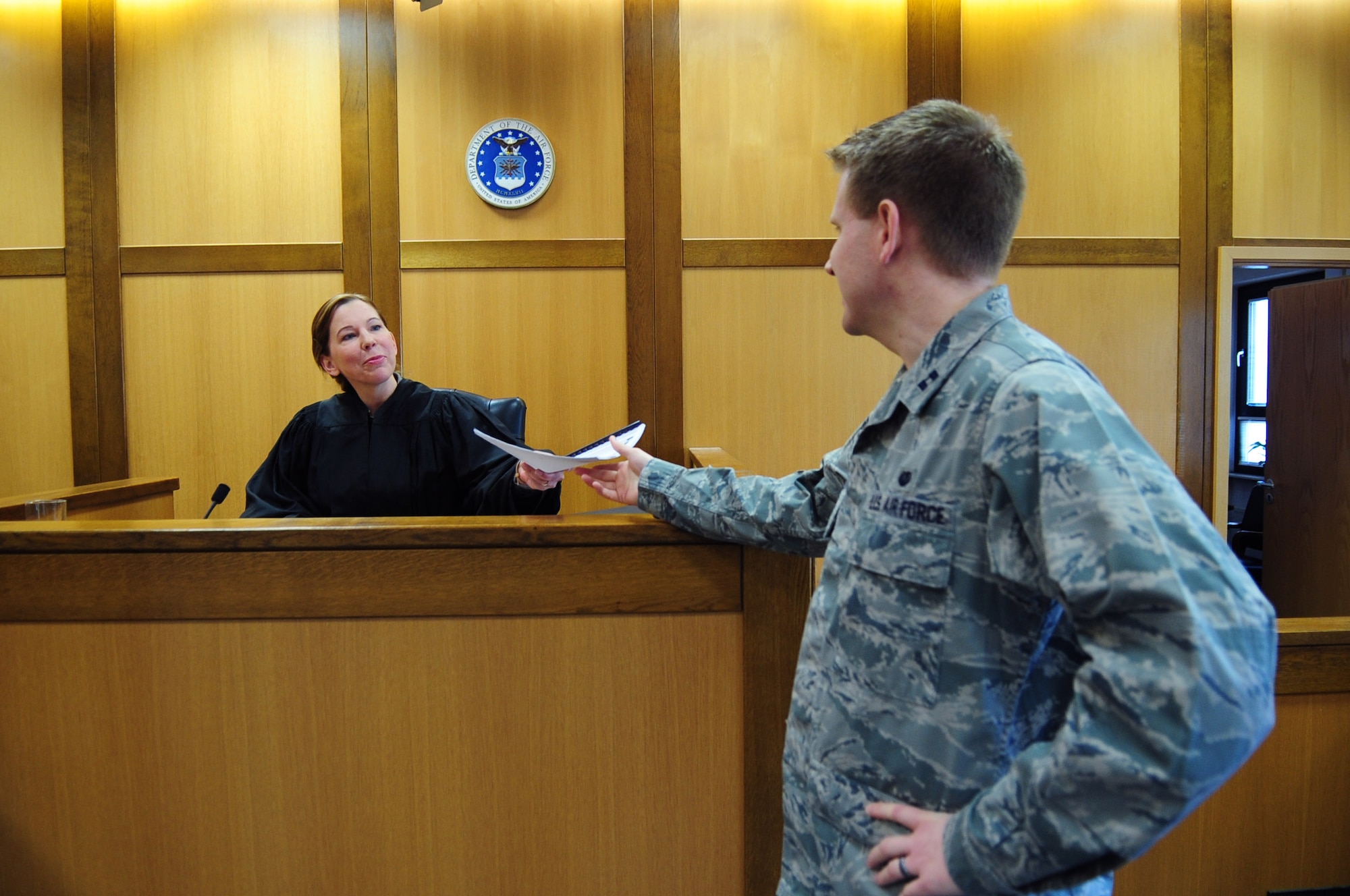 Lt. Col. Olga Sinquefield, 86th Airlift Wing Judge Advocate, receives paperwork from Capt. Dan Colton, 86th AW, Law Center, Ramstein Air Base, Germany, March 20, 2012. Members at the Law Center strive to provide on-time, on-target legal advice and services to the Kaiserslautern Military Community. (U.S. Air Force photo by Senior Airman Brittany Perry)