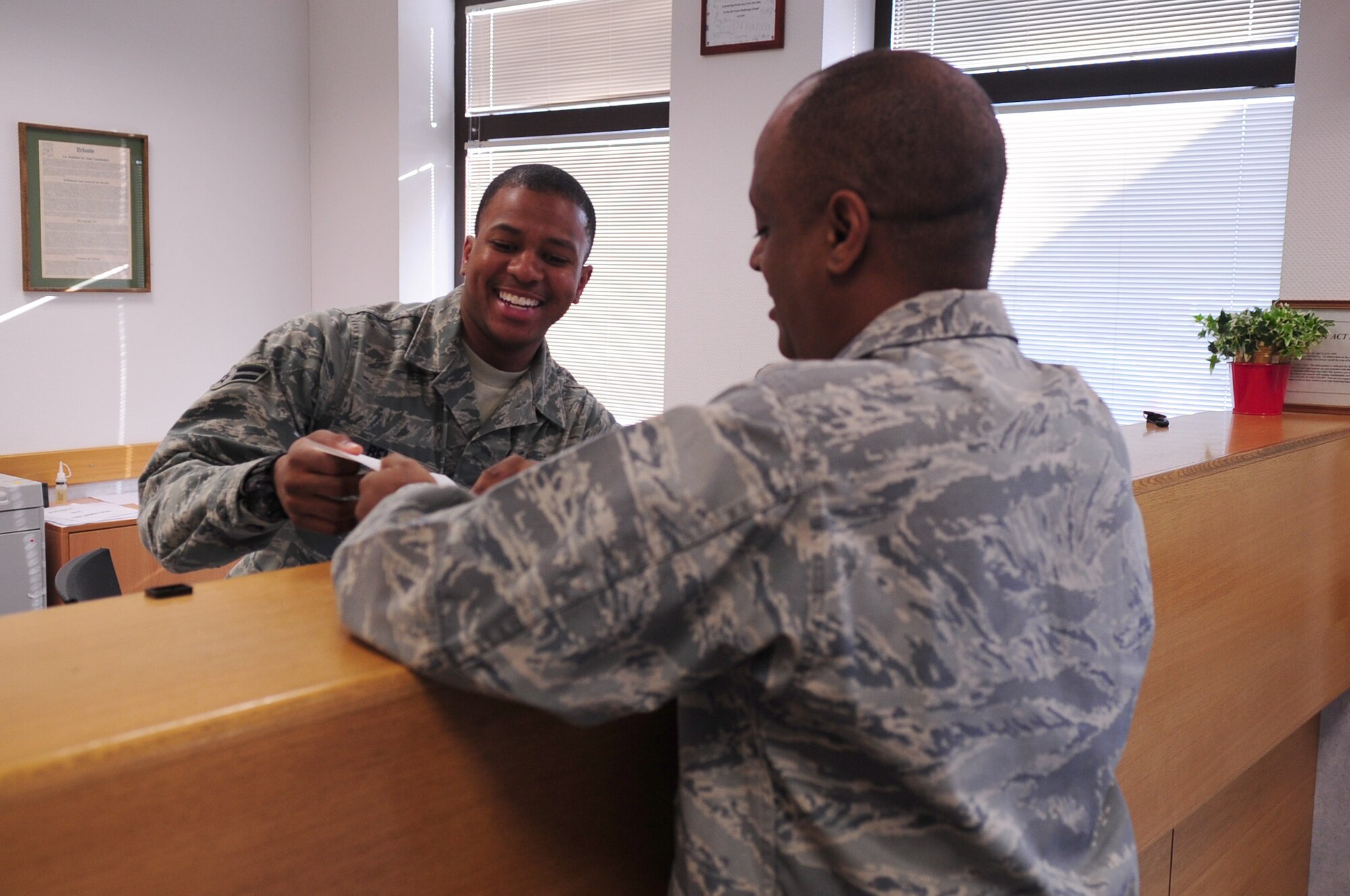 Airman 1st Class Chinua Belle, 86th Airlift Wing, assists a customer at the Law Center, Ramstein Air Base, Germany, March 20, 2012. Members at the Law Center strive to provide on-time, on-target legal advice and services to the Kaiserslautern Military Community. (U.S. Air Force photo by Senior Airman Brittany Perry)