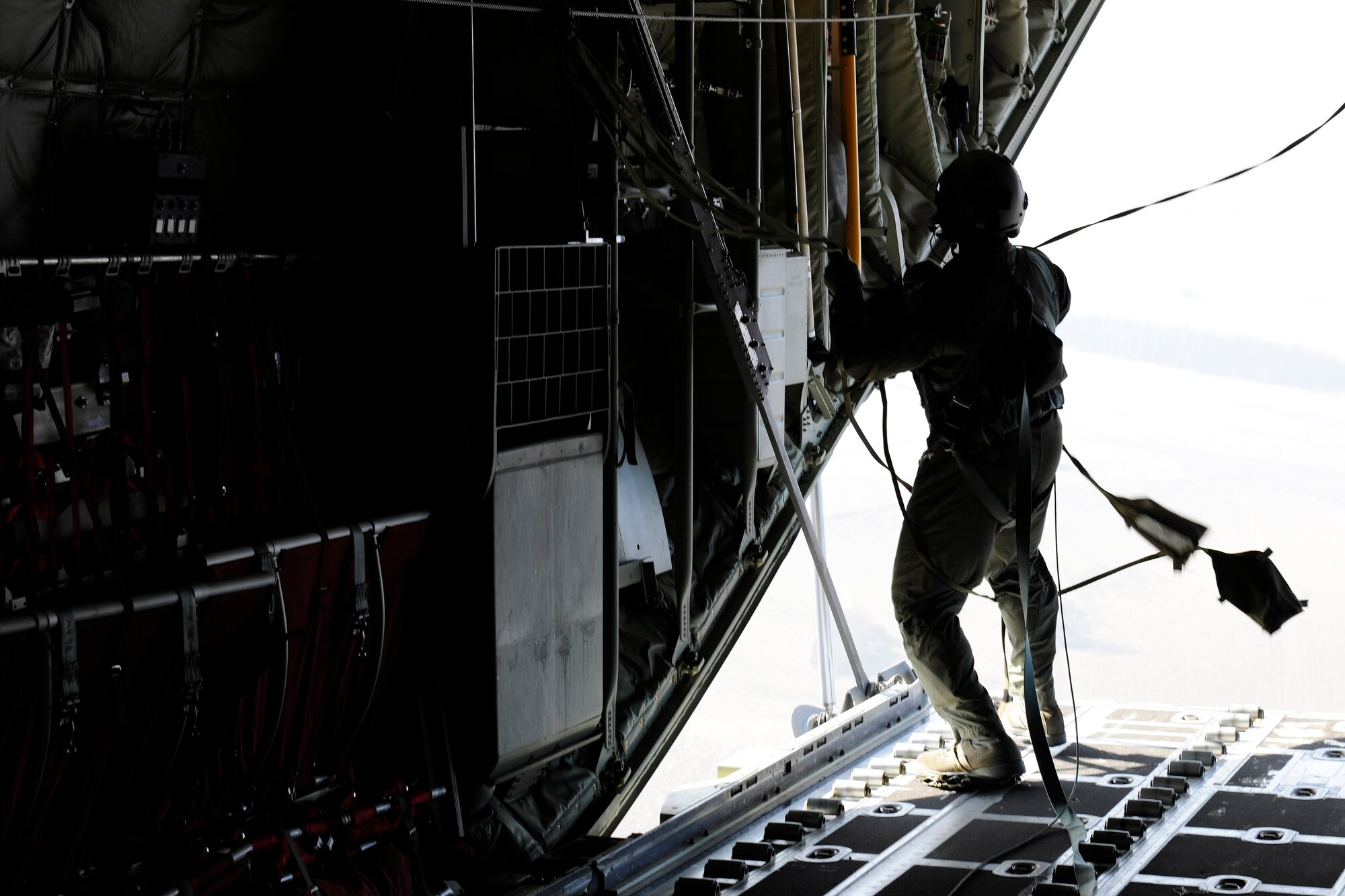 Chief Master Sgt. Lewis Holston, 37th Airlift Squadron superintendent, oversees the ten-bundle container deployment system drop out of the cargo bay of a C130J, March 16, 2012 at Ramstein Air Base, Germany.  The cargo was dropped in order to support field-training exercises for the 173rd Airborne Brigade Combat Team from Vicenza, Italy. This training gave pilots and loadmasters here an opportunity to practice this type of airdrop.  (U.S. Air Force photo/Staff Sgt. Chris Willis)