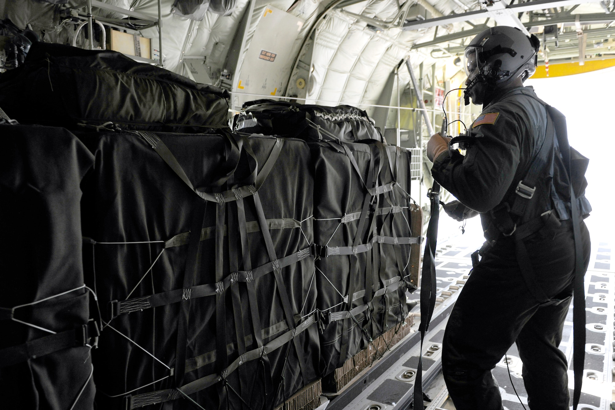 Chief Master Sgt. Lewis Holston, 37th Airlift Squadron superintendent, oversees the ten-bundle container deployment system drop out of the cargo bay of a C130J, March 16, 2012 at Ramstein Air Base, Germany.  The cargo was dropped in order to support field-training exercises for the 173rd Airborne Brigade Combat Team from Vicenza, Italy. This training gave pilots and loadmasters here an opportunity to practice this type of airdrop.  (U.S. Air Force photo/Staff Sgt. Chris Willis)