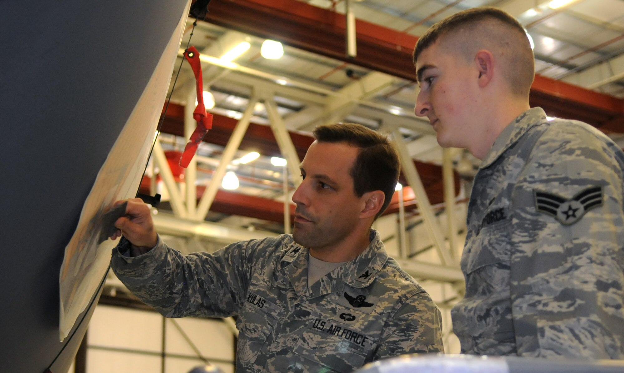 RAF MILDENHALL, England – Col. Christopher Kulas, 100th Air Refueling Wing commander, under the watchful eye of Senior Airman William Hickey, 100th Maintenance Squadron, affixes the historic emblem of the 100th Bomb Group – the 100th ARW’s World War II predecessor – to the nose of KC-135 Stratotanker 58-0100 during a small ceremony March 14, 2012. The emblem was first approved in March 1944, when the 100th BG was flying B-17s out of RAF Thorpe Abbots over Nazi Germany. (U.S. Air Force photo by Staff Sgt. Austin M. May)