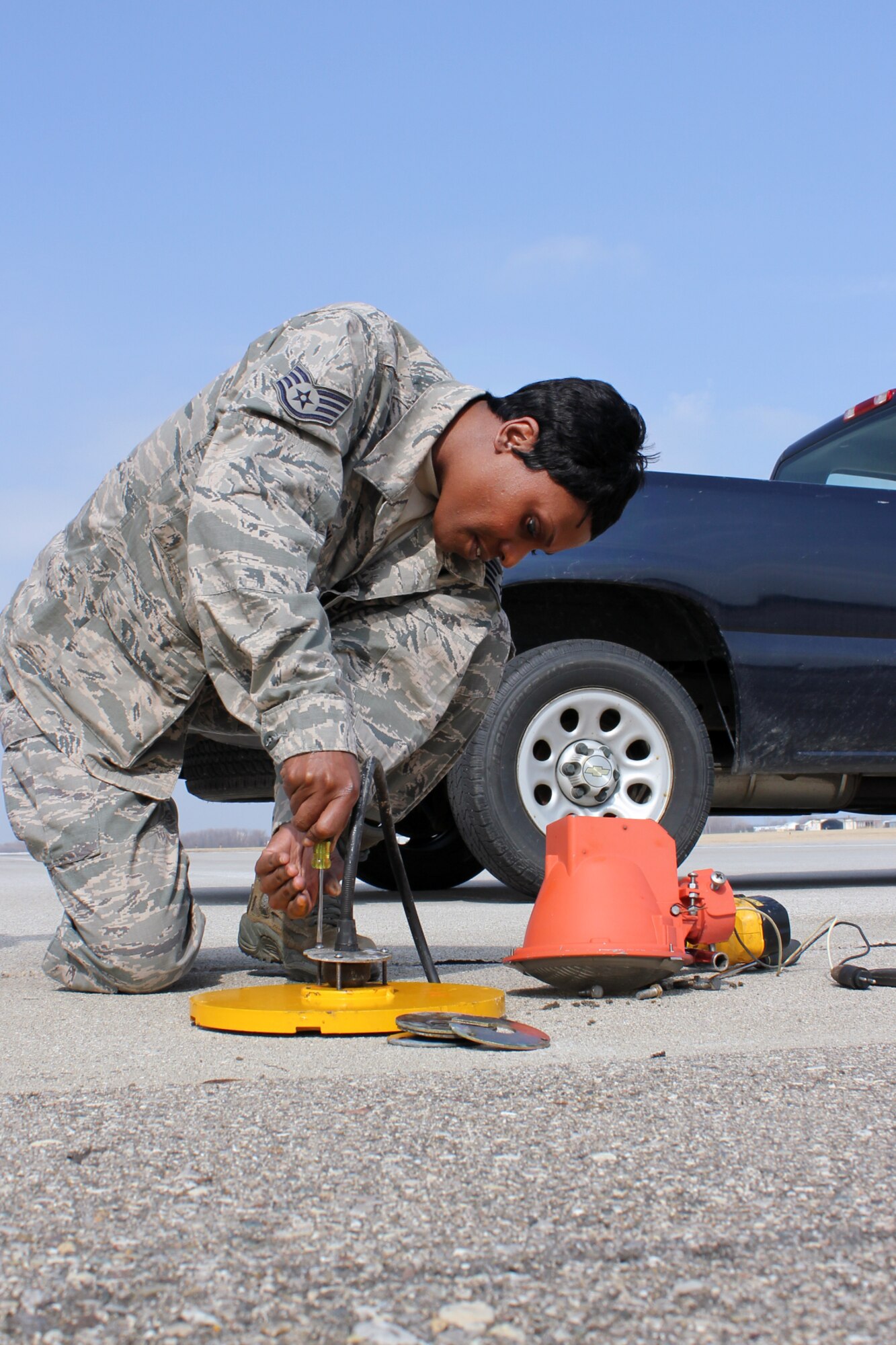 Staff Sgt. Fran Dixon changes out a light fixture on the runway as part of her duties as an electrician in the 127th Civil Engineer Squadron at Selfridge Air National Guard Base, Mich. “I’m proud to wear the uniform and to do my small part and serve our country,” she said. (U.S. Air Force photo by TSgt. Dan Heaton)