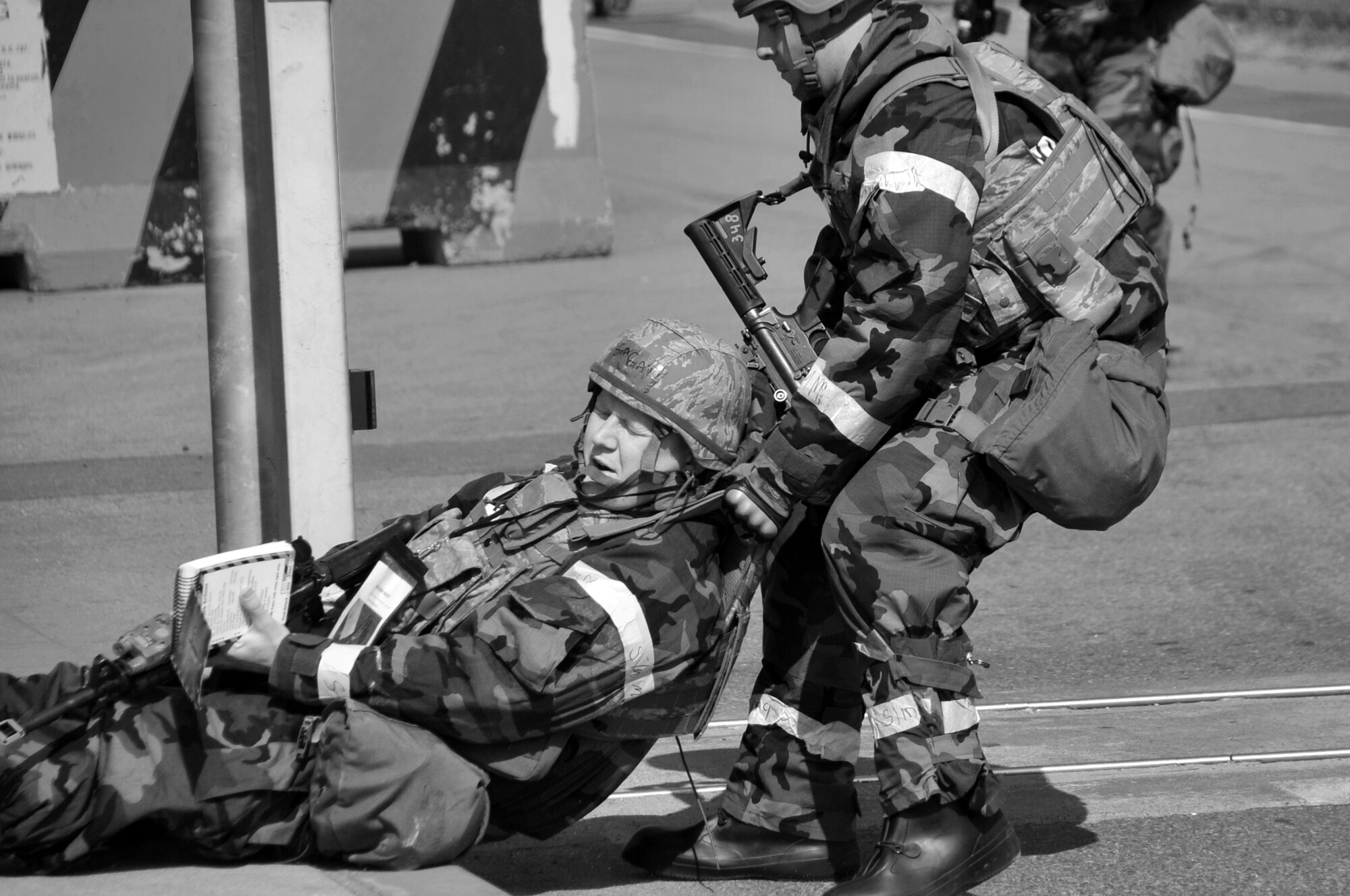Senior Airman Tyler Johnson, 51st Security Forces Squadron, pulls his wounded wingman to safety after    injuring his leg on a simulated unexploded ordinance event, March 20, 2012, during BM 12-01. Osan Airmen are give a number of scenarios to test their ability to defend the base and conduct daily operations during a heightened state of readiness. (U.S. Air Force photo/Staff Sgt. Craig R. Cisek)