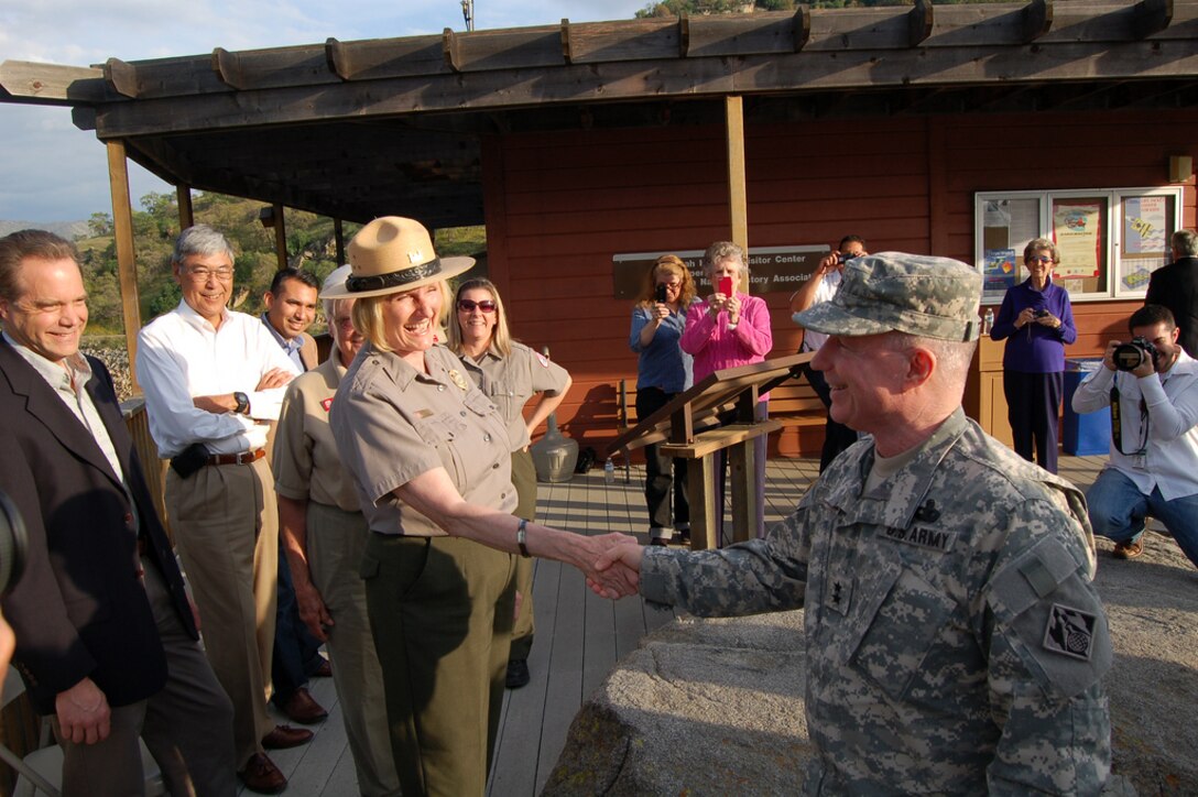 LAKE KAWEAH, Calif. — Maj. Gen. Merdith "Bo" Temple, acting commanding general and acting chief of engineers (left), offers a personally inscribed book to Valerie McKay, Sacramento District park ranger, here on March 15. Temple met with McKay at Lake Kaweah’s visitors center after she responded to his holiday e-mail referencing the historic Christmas Day Truce of 1914. McKay’s late grandfather fought in World War I for the British and participated in the famous event, where British and German soldiers laid down their arms to sing and remember Christmas before resuming fighting. 