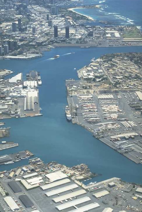 Photograph of Honolulu Harbor on the island of Oahu. The project is located at the southern edge of the downtown and industrial portion of Honolulu. It is the principal port for the State of Hawaii and an important link in the commerce of the Pacific Basin. The harbor is the largest nonmilitary port on Oahu. Since its initial construction by the Hawaiian monarchy in 1899, the harbor has been expanded and deepened many times. This project represented not only the first federal improvements to the harbor, but also the first Corps civil works project to be undertaken in Hawaii in 1905. 
