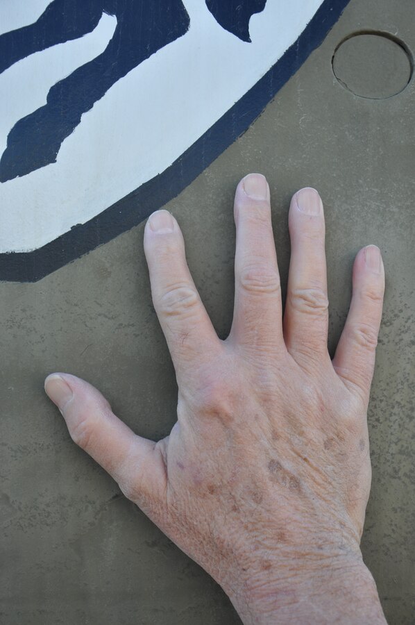 Curt Lambert, base photographer aboard MCLB Barstow holds his hand on ‘659,’ a UH-1H Utility Helicopter he flew during the::r::::n::Vietnam War. Lambert recently discovered the helicopter was on display at National Training Center Fort Irwin.::r::::n::