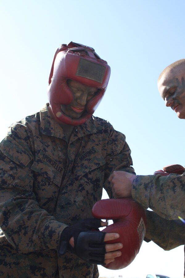 Recruit Colten C. Sponseller, platoon 2142, Company G, 2nd Recruit Training Battalion, puts on protective equipment to begin 'High Iams Drive' body sparring March 20 at Weapons and Field Training Battalion aboard Camp Pendleton. Sponseller joined the Marine Corps in hopes that this would be a stepping stone toward his dream of becoming a senator. He believes the Marine Corps can teach him things he wouldn't learn anywhere else.