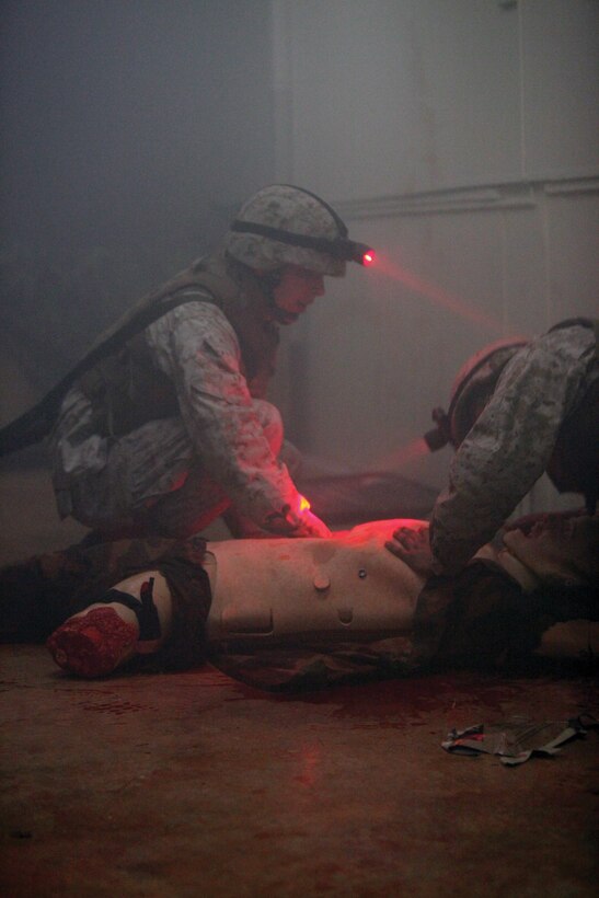 Two Marines prepare to treat a simulated casualty for a sucking-chest wound during the combat lifesaver course at the III MEF Tactical Medical Simulated Casualty Center on Camp Hansen March 21.