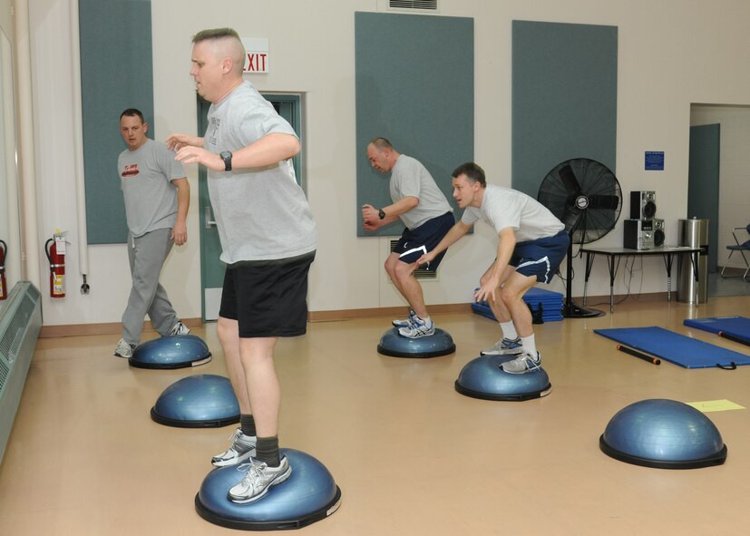 Lt. Col. Bradley Baugh, 319th Operations Support Squadron commander, tests his balance on a bosu ball during the Soar into Shape obstacle course March 8, 2012, on Grand Forks Air Force Base, N.D.  Soar into Shape is a nine-week challenge allowing participants to decide whether to lose or maintain weight, ultimately improving their overall physical health.  (U.S. Air Force photo/Airman 1st Class Ashley N. Taylor)