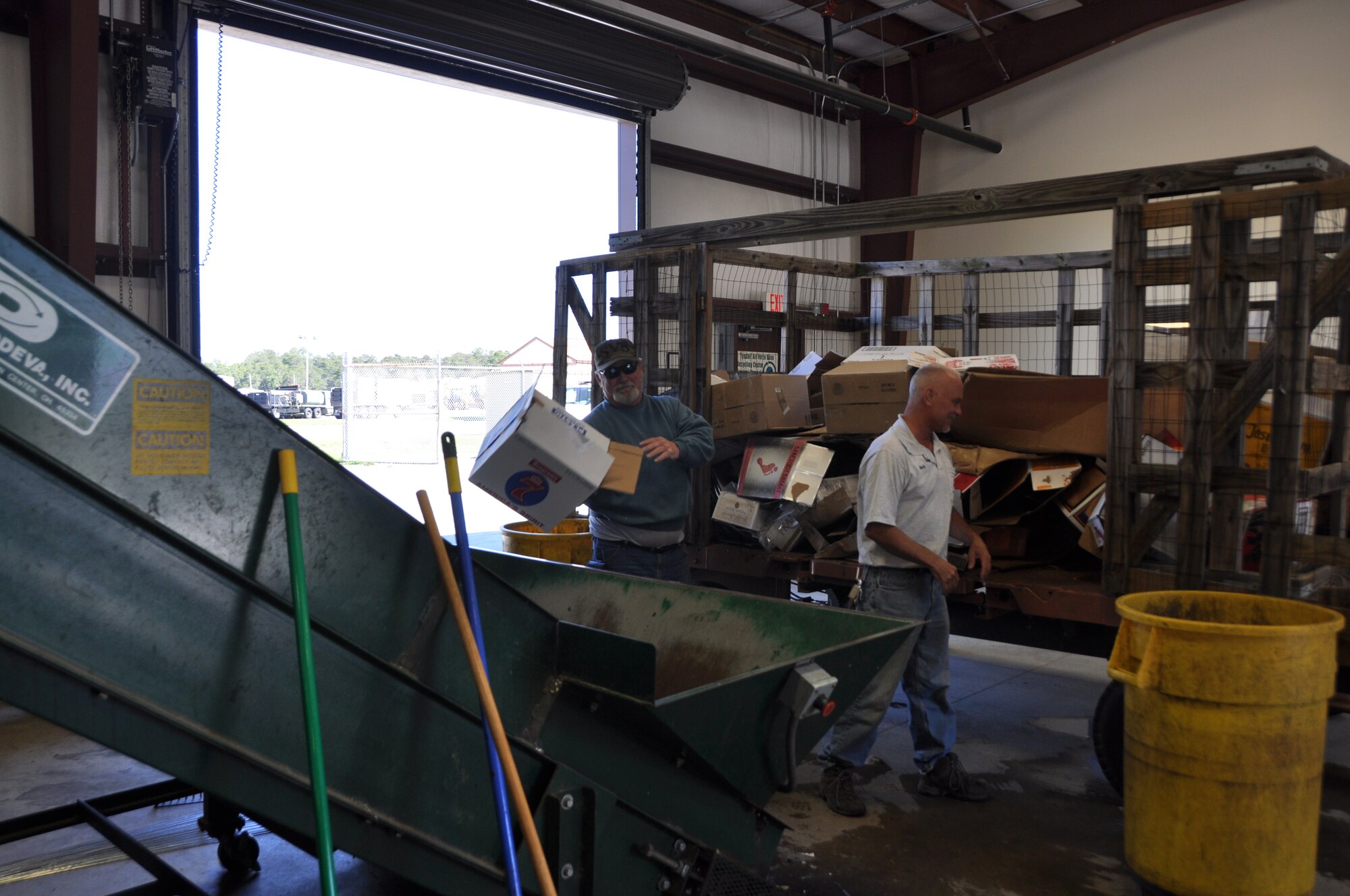 Mr. Bill Strickland and Mr. Mark Dall, both recycle center employees, unload a cardboard trailer. (U.S. Air Force photo by Senior Airman Rachelle Elsea)