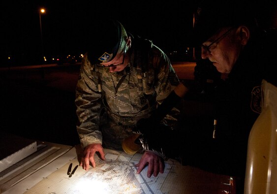 Tech. Sgt. Martin Evans, 28th Security Forces Squadron flight chief, and Officer Glenn Waters, 28th SFS senior police officer, coordinate and establish a cordon following a simulated bomb threat during an Operational Readiness Exercise at Ellsworth Air Force Base, S.D., March 16, 2012. Simulated emergencies tested the ability of Airmen to respond quickly and appropriately likely event scenarios. (U.S. Air Force photo by Airman 1st Class Kate Thornton/Released)