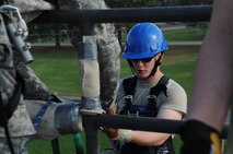U.S. Air Force Senior Airman Christopher Traina waits for a safety check before rappelling off the burn tower on Seymour Johnson Air Force Base, N.C., March 20, 2012. Prior to initiating a repel, an instructor must perform a final safety check in order to prevent inadvertent injury. Traina is from the 9th Civil Engineer Squadron at Beale Air Force Base, Calif., and hails from Patterson, Calif. (U.S. Air Force photo/Airman 1st Class Aubrey Robinson/Released)