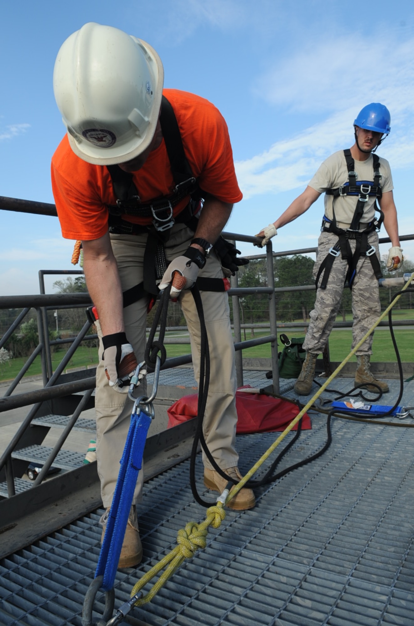 Joseph Gomos tightens a carabiner as U.S. Air Force Staff Sgt. Aaron Shields watches on Seymour Johnson Air Force Base, N.C., March 20, 2012. Carabiners are frequently used to connect different mechanisms in safety systems for activities such as rope rescues. Gomos is a Department of Defense Fire Academy instructor at Goodfellow Air Force Base, Texas.  Shields is a 4th Civil Engineer Squadron firefighter and hails from Idaho Falls, Idaho. (U.S. Air Force photo/Airman 1st Class Aubrey Robinson/Released)
