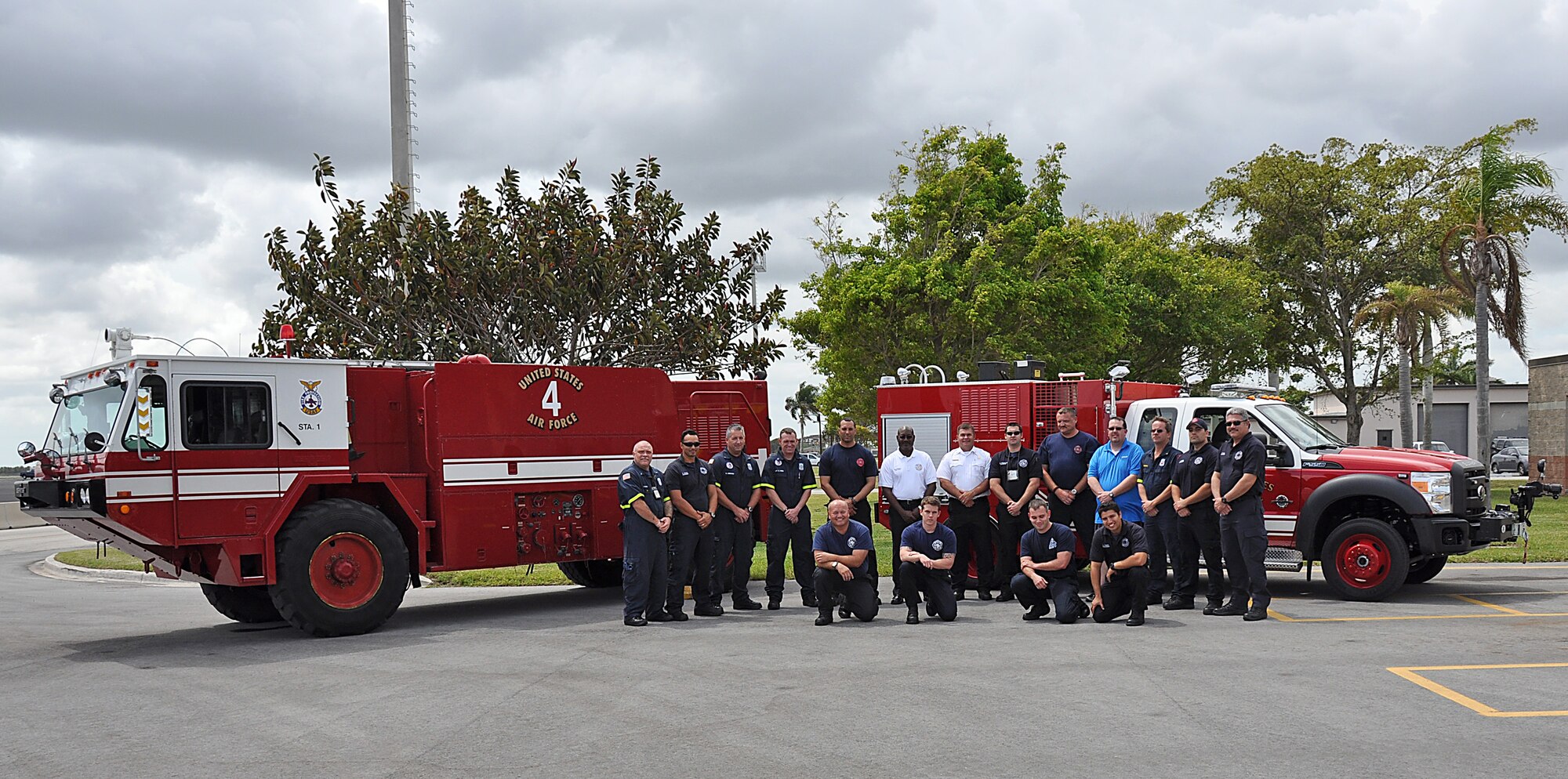Homestead Air Reserve Base Fire Department's firefighters pose for a group picture in front of the departments P-19 vehicle and its replacement, the P-34 rapid intervention vehicle, on Mar. 20. The new truck will provide the station with a more technologically advanced rapid intervention vehicle that is lighter and more efficient than the P-34 vehicle. (U. S. Air Force Photo by Senior Airman Jacob Jimenez, 482nd Fighter Wing Public Affairs.)