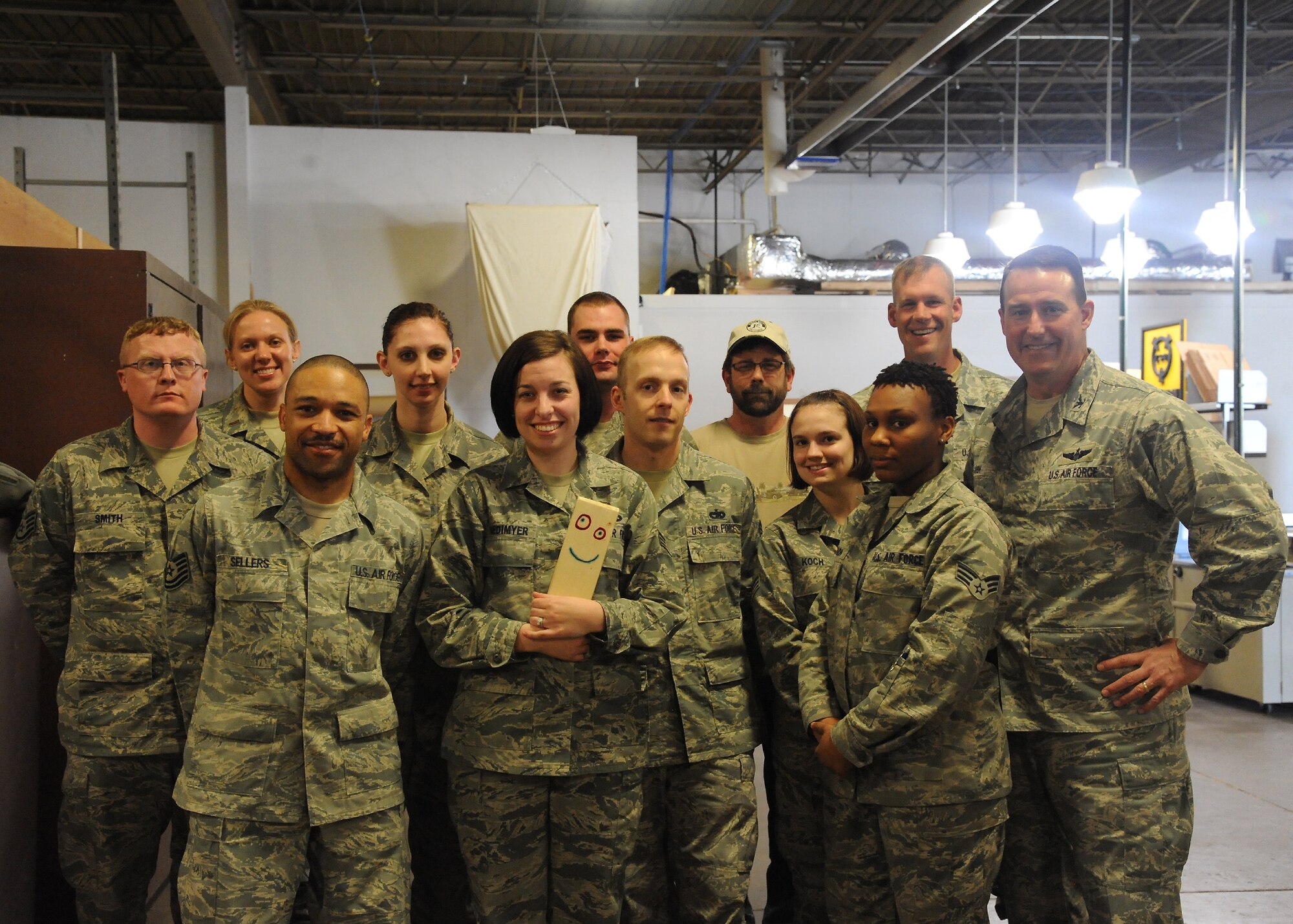 Members of 319th Logistics Readiness Deployment Distribution Cargo team pose for a photo with Col. Tim Bush, 319th Air Base Wing commander, and Command Chief Master Sgt. David Carlson, 319th ABW, on March 20, 2012 on Grand Forks Air Force Base, N.D.  Bush and members of the 319th ABW celebrated the opening of a new Traffic Management Office workspace. (U.S. Air Force photo by Airman 1st Class Xavier Navarro)