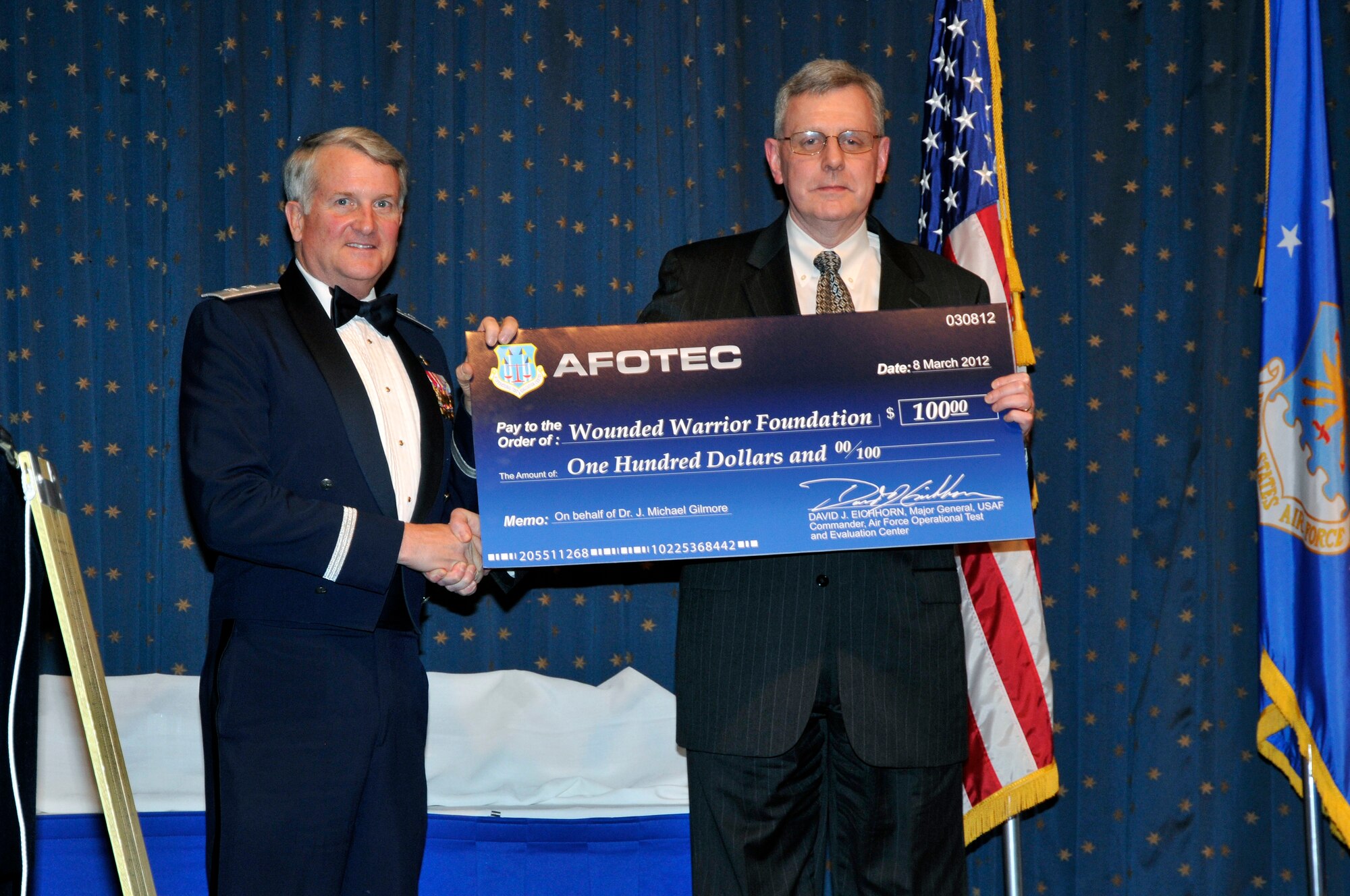 Maj. Gen. David J. Eichhorn, Air Force Operational Test and Evaluation Center Commander, presents guest speaker Dr. J. Michael Gilmore, Director of Operational Test and Evaluation, a donation to the Wounded Warriors Foundation in his name in appreciation for attending and speaking at the 2011 AFOTEC awards banquet.